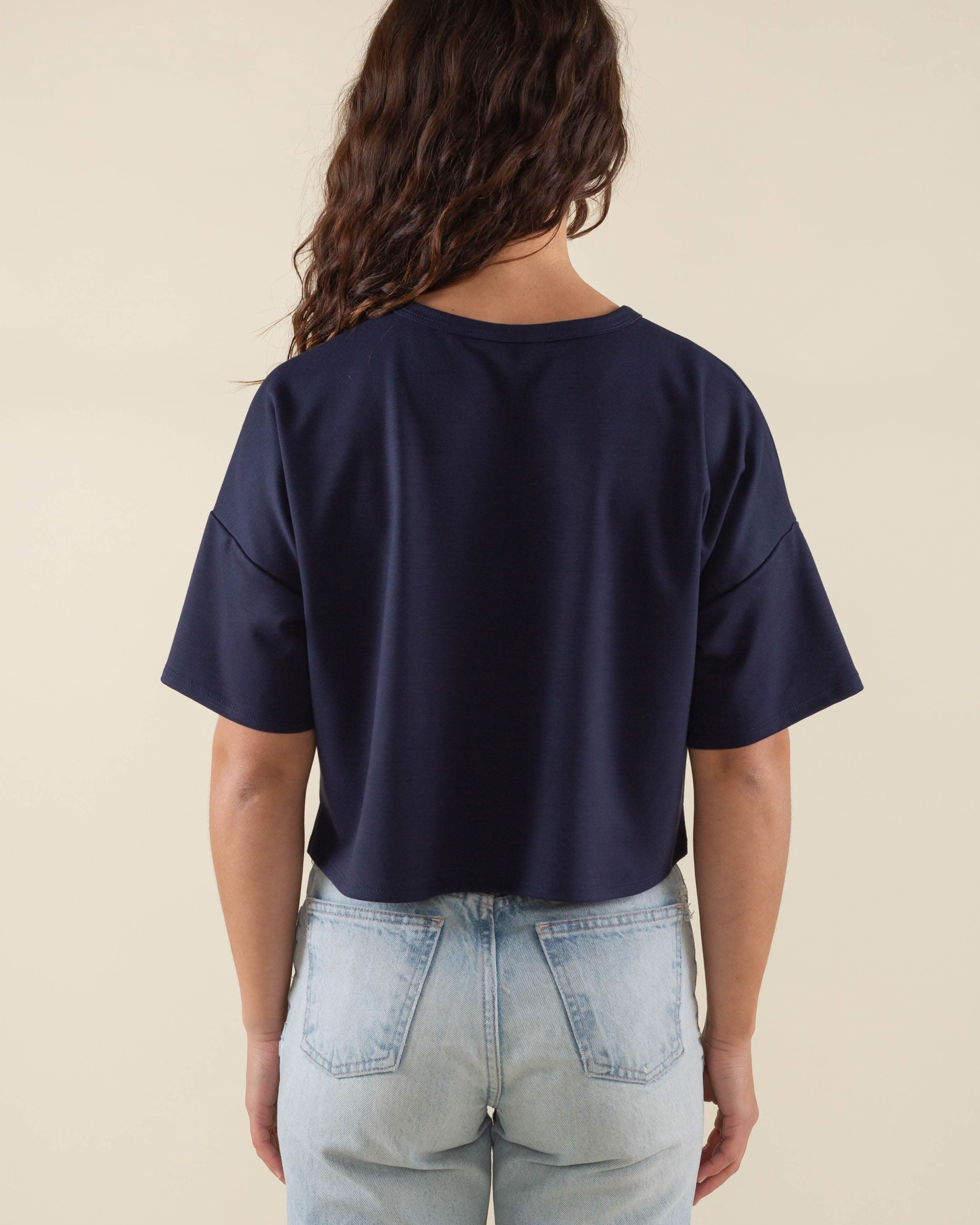 Woman wearing navy, short sleeve, jersey, cropped t-shirt and blue jeans