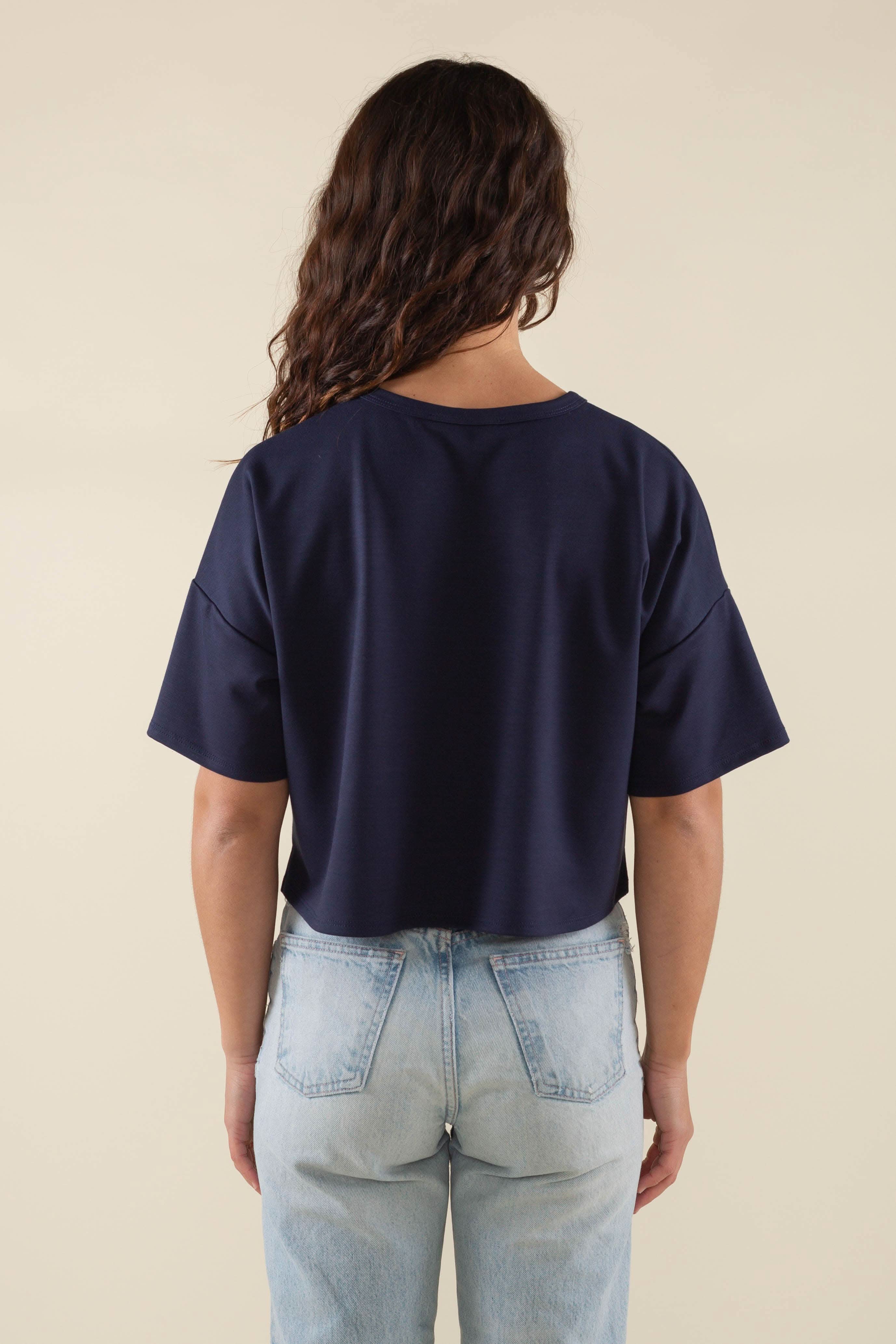 Woman wearing navy, short sleeve, jersey, cropped t-shirt and blue jeans