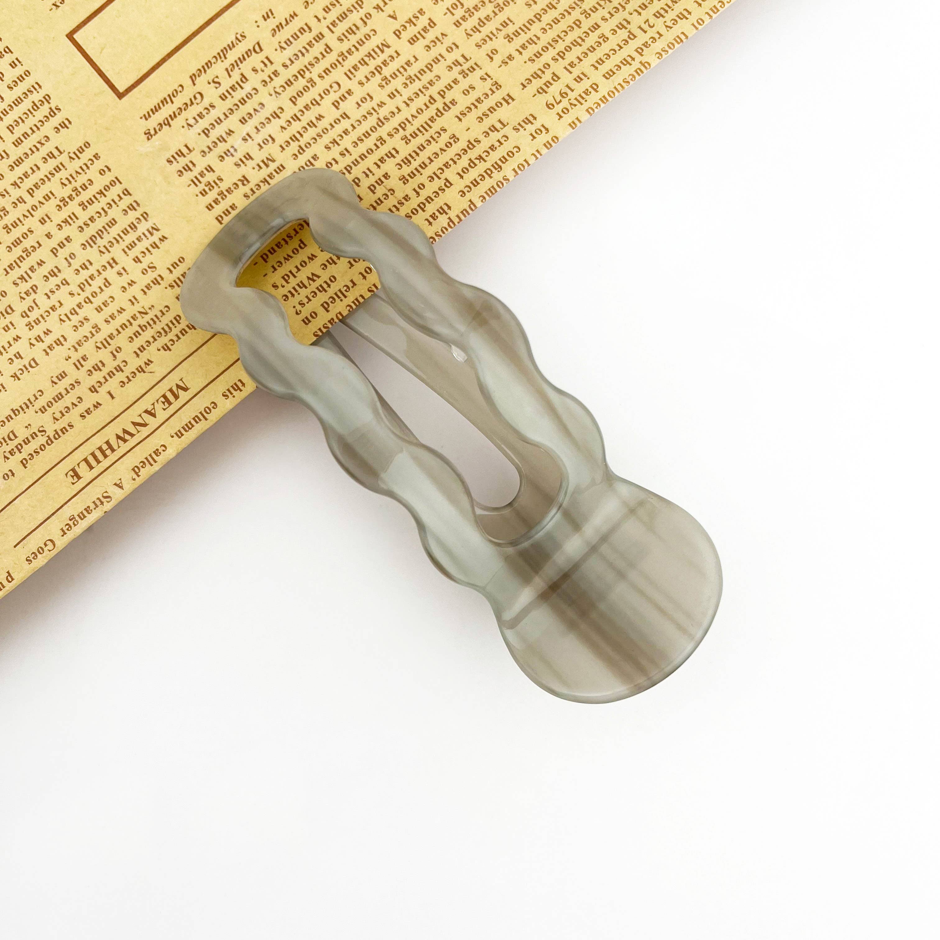 Clear plastic clip on a newspaper background