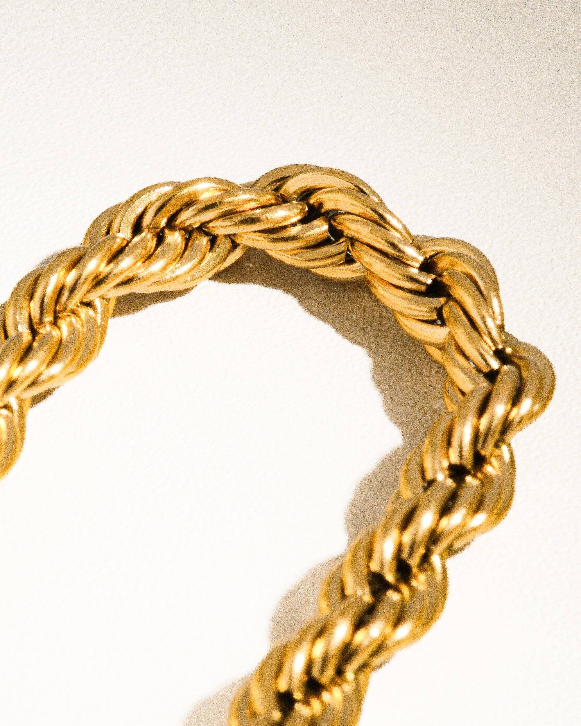 Gold braided ring on a light background