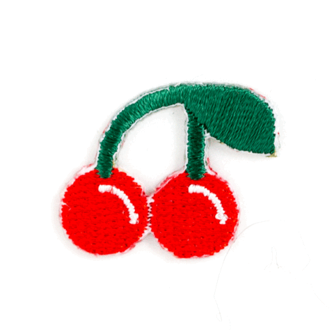 Embroidered patch of two red cherries with green leaves on a white background