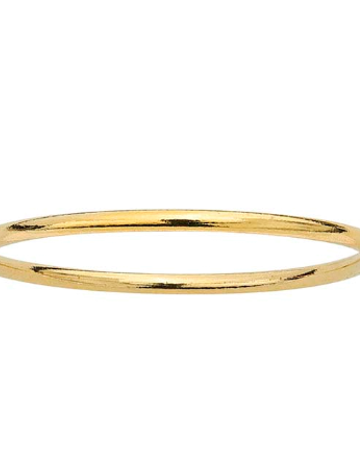 Simple thin gold ring for stacking laying on a white background