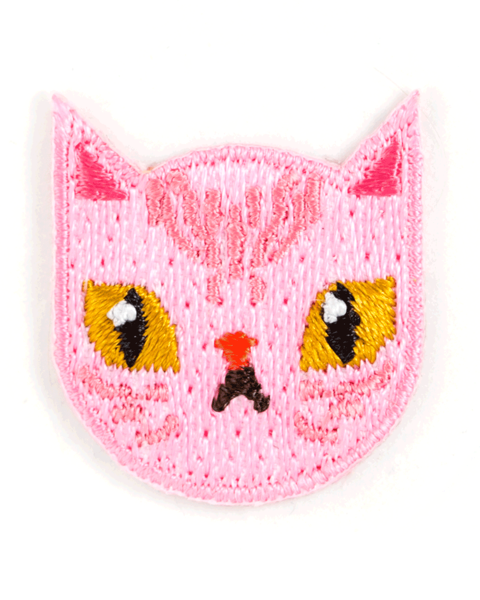 Pink knitted cat face with yellow eyes and red nose on a white background
