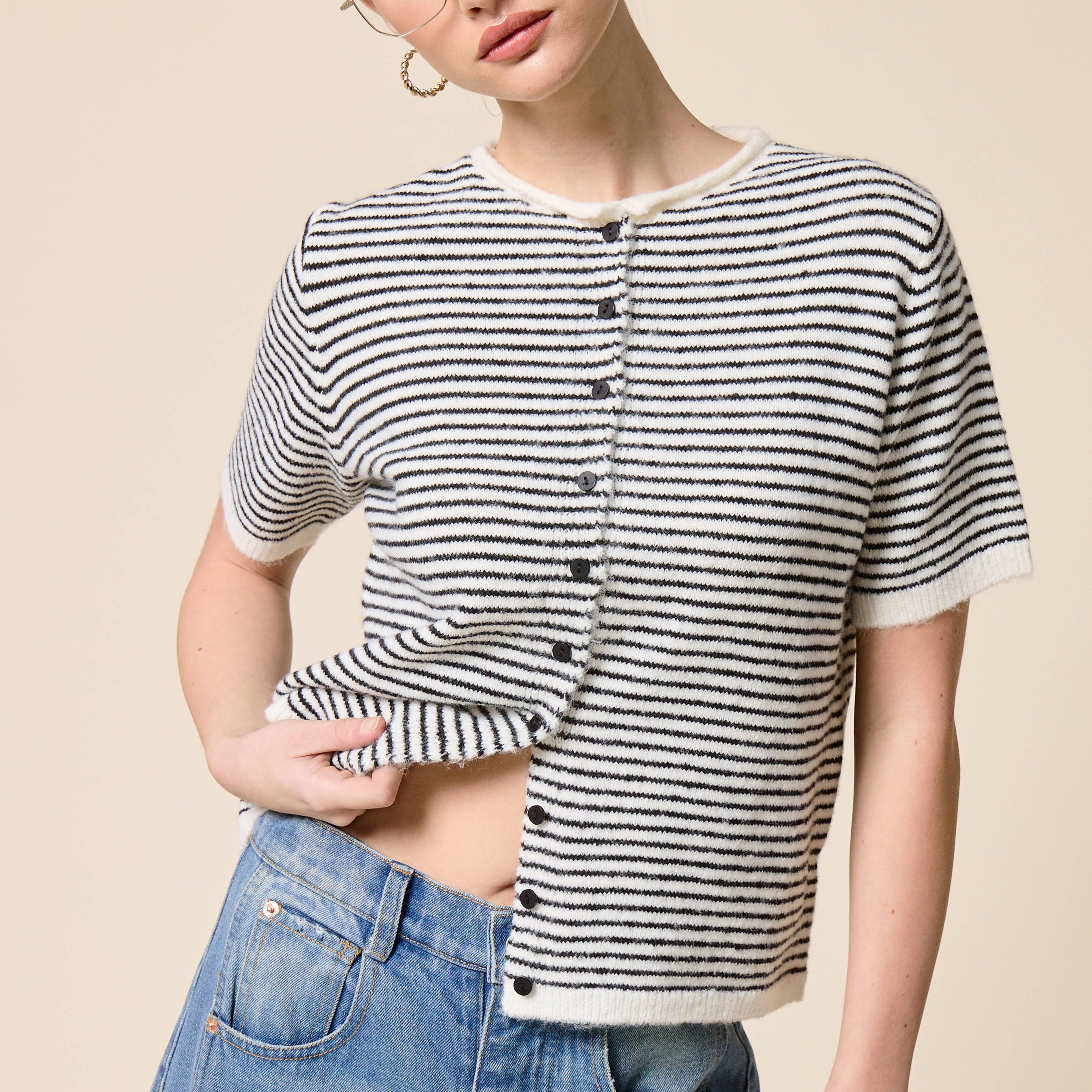 Woman wearing a black and white striped shirt with a beige background