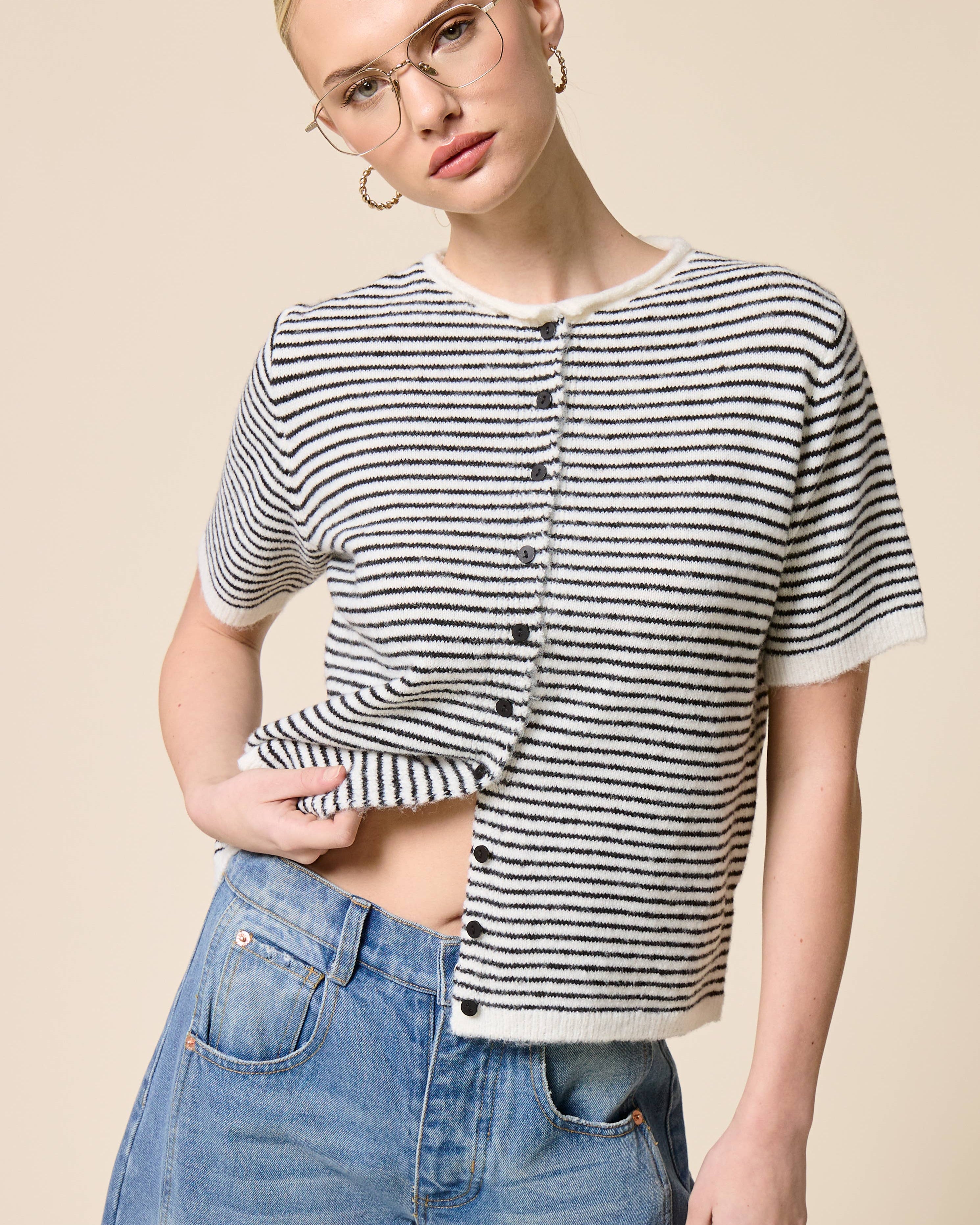 Woman wearing a black and white striped shirt with a beige background