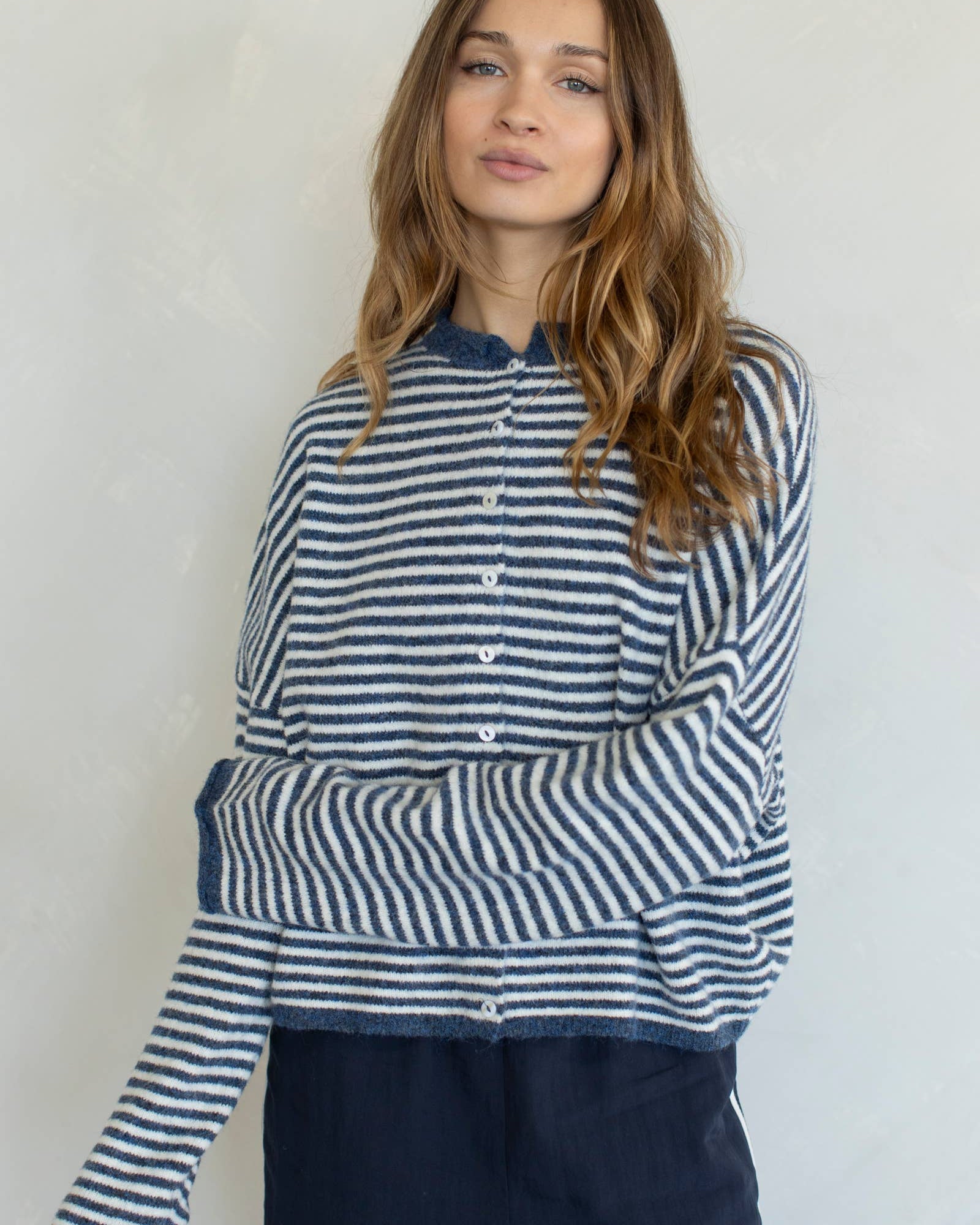 Woman wearing a blue and white striped shirt against a plain background
