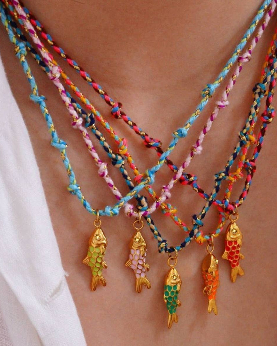 Colorful braided necklace with fish pendants on a person's neck