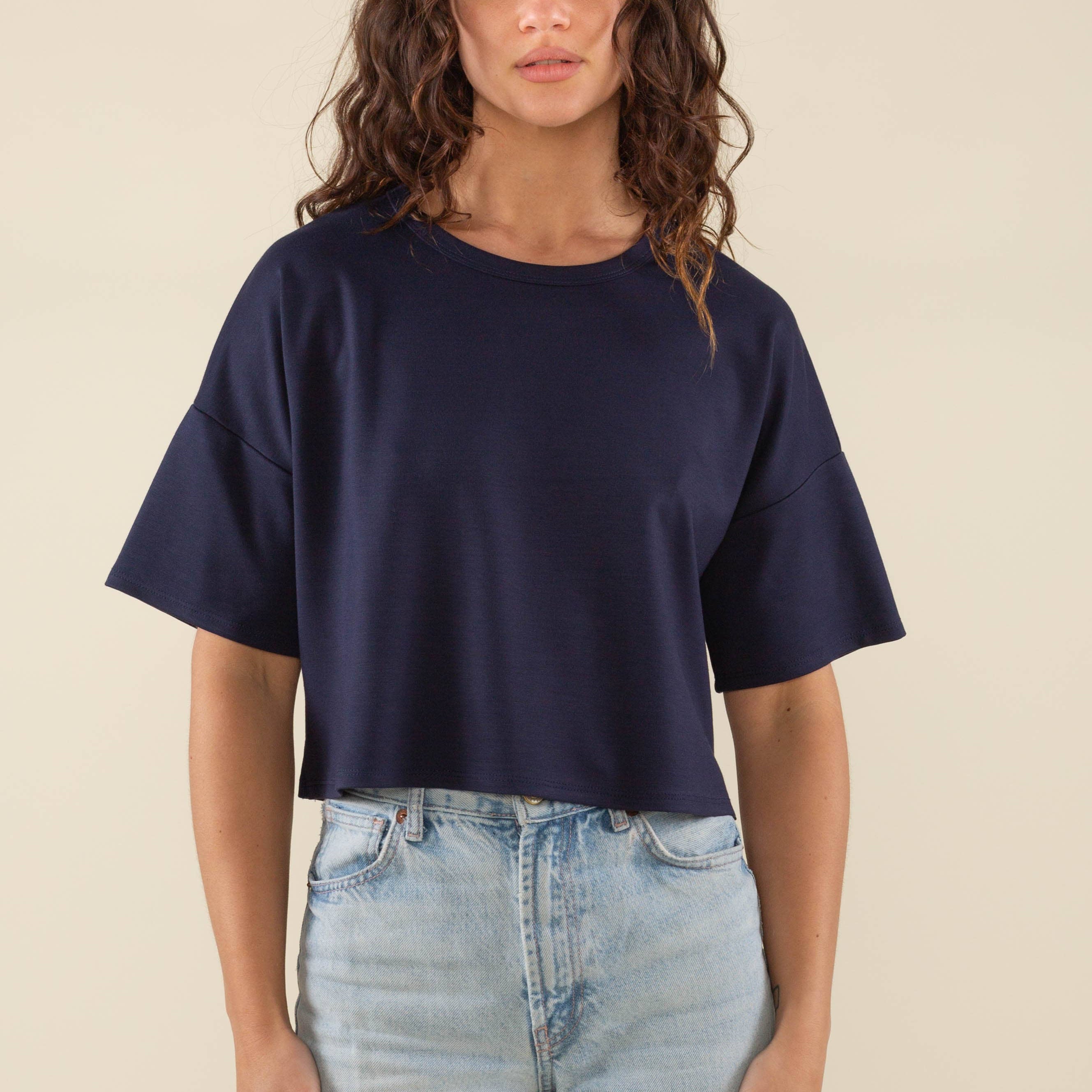 Woman wearing navy, short sleeve, jersey, cropped t-shirt and blue jeans