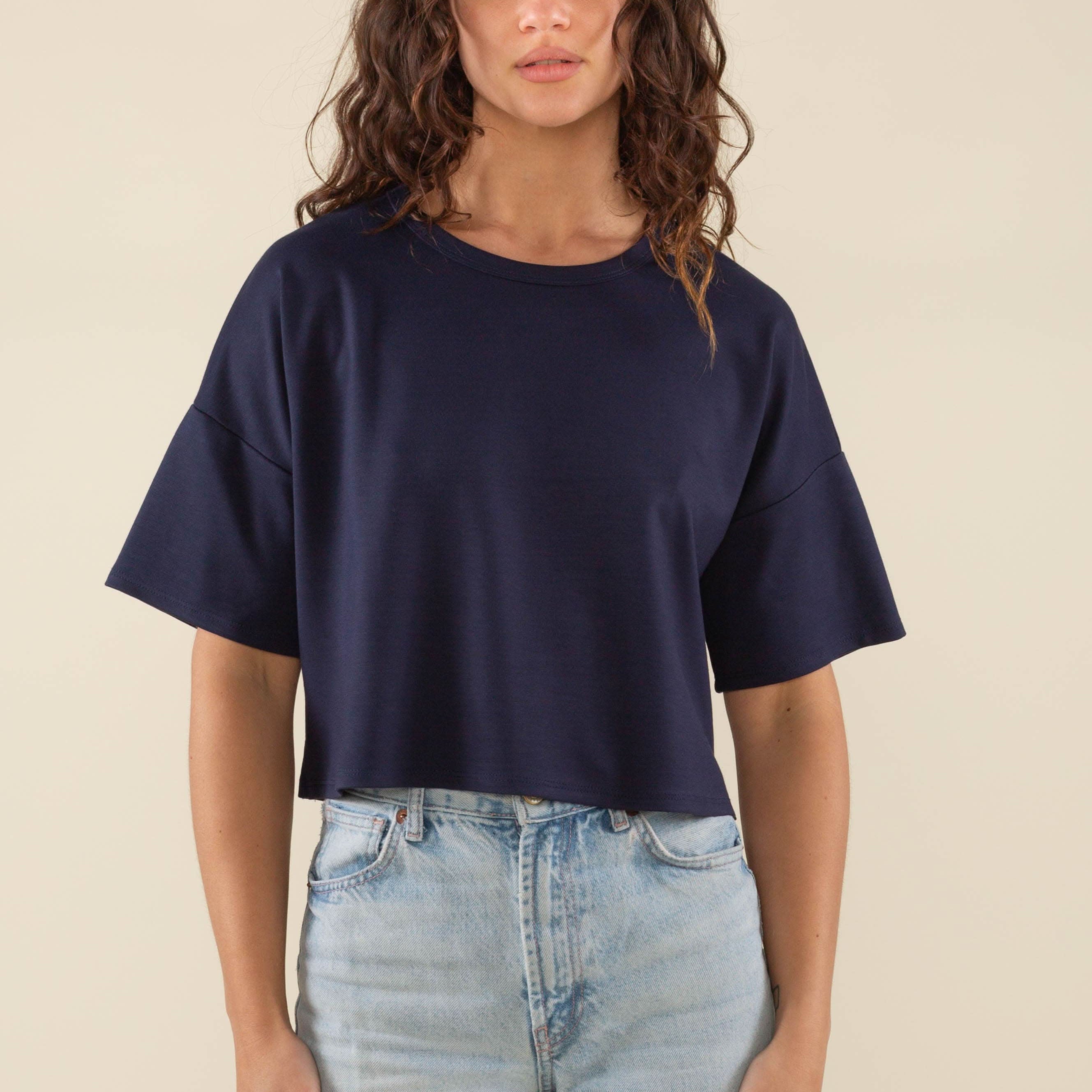 Woman wearing navy, short sleeve, jersey, cropped t-shirt and blue jeans