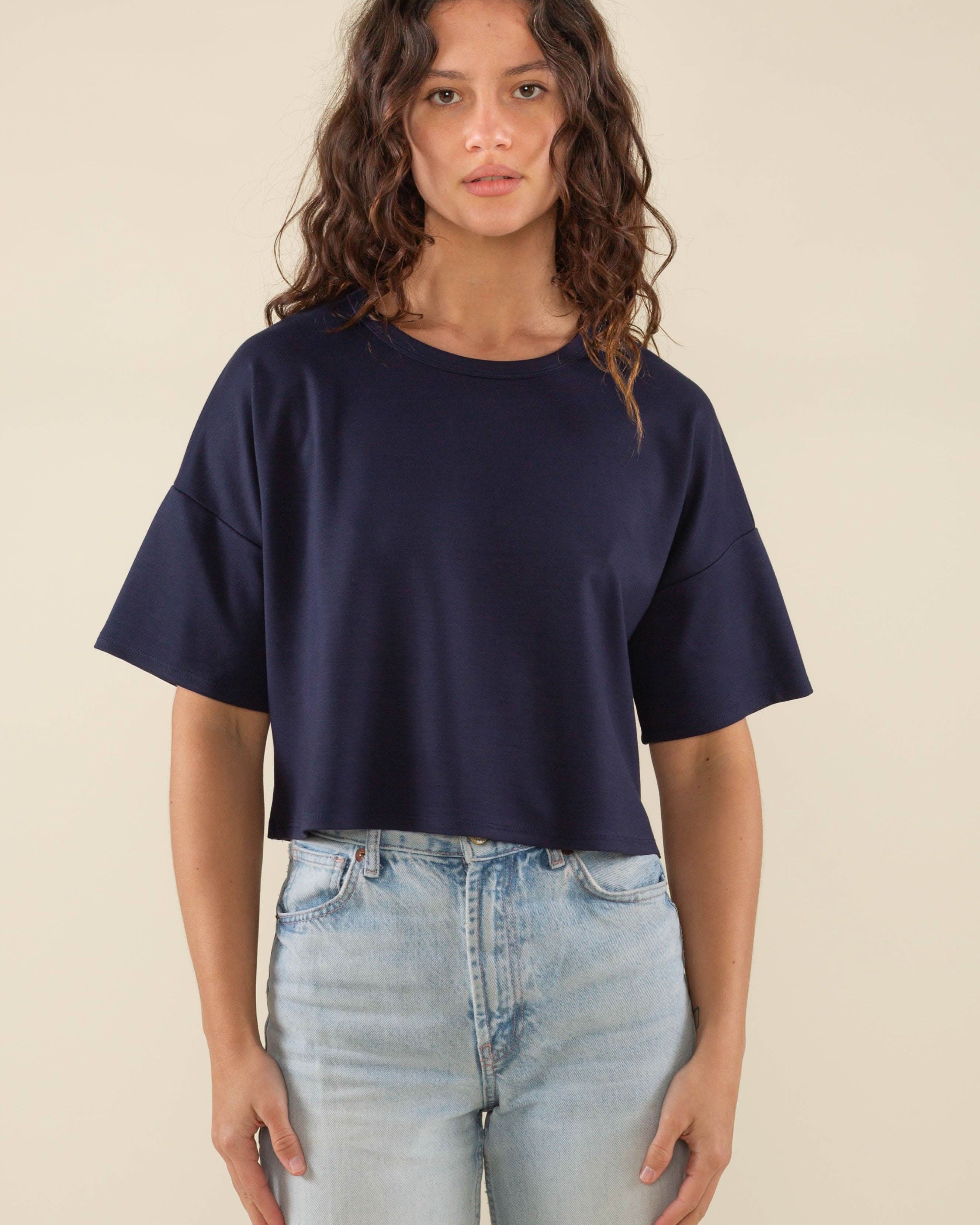 Woman wearing navy, short sleeve, jersey, cropped t-shirt and blue jeans