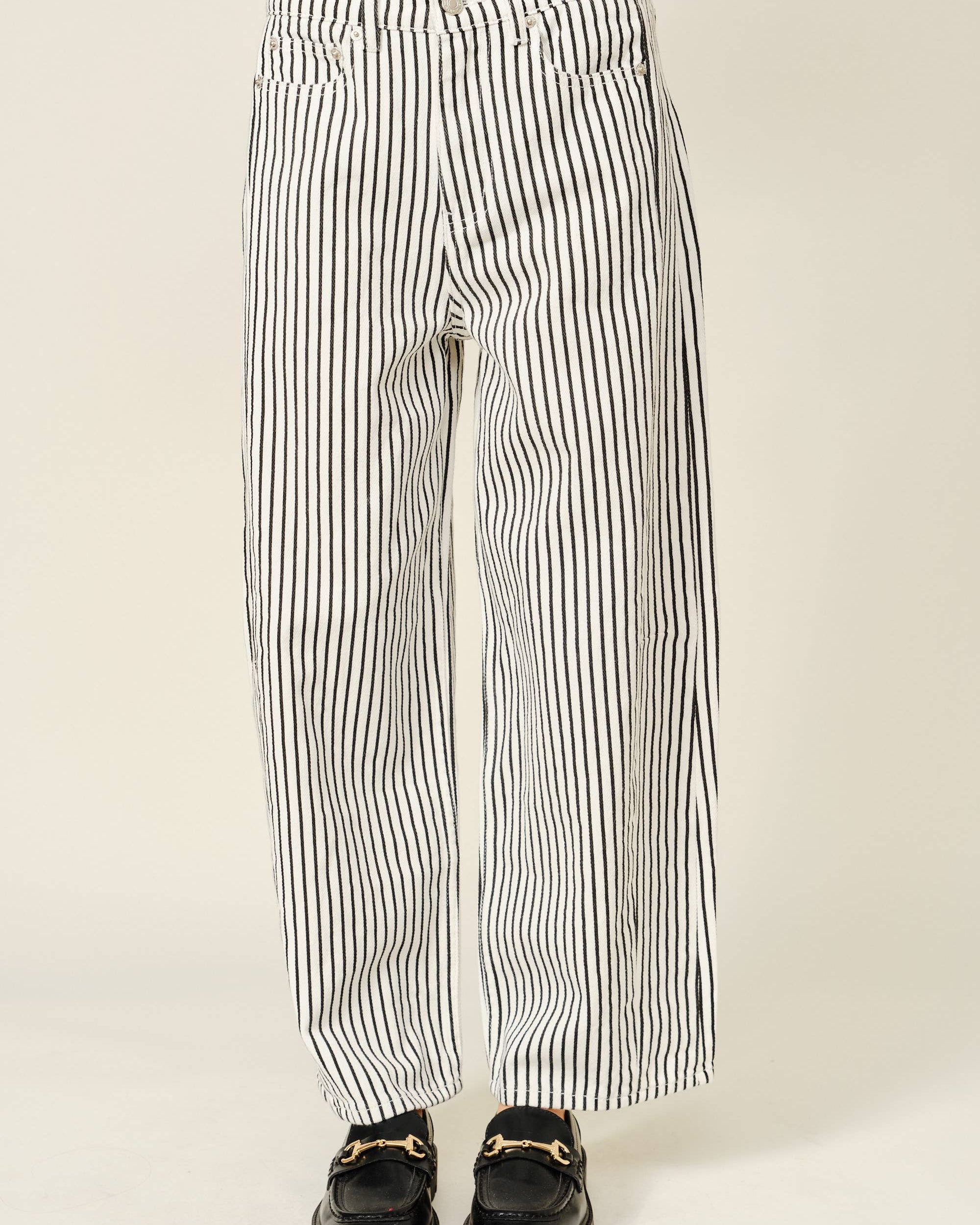 Black and white striped pants worn by a person on a plain background