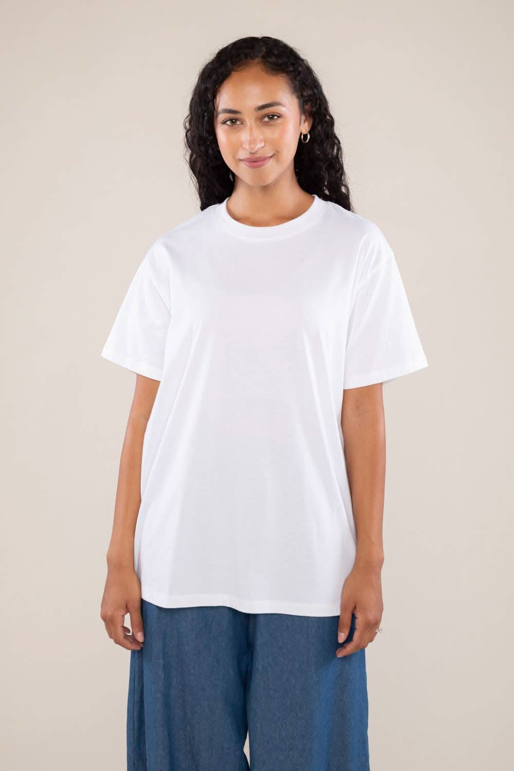 Woman wearing white boxy, oversized, shirt sleeved, tee t-shirt and jeans
