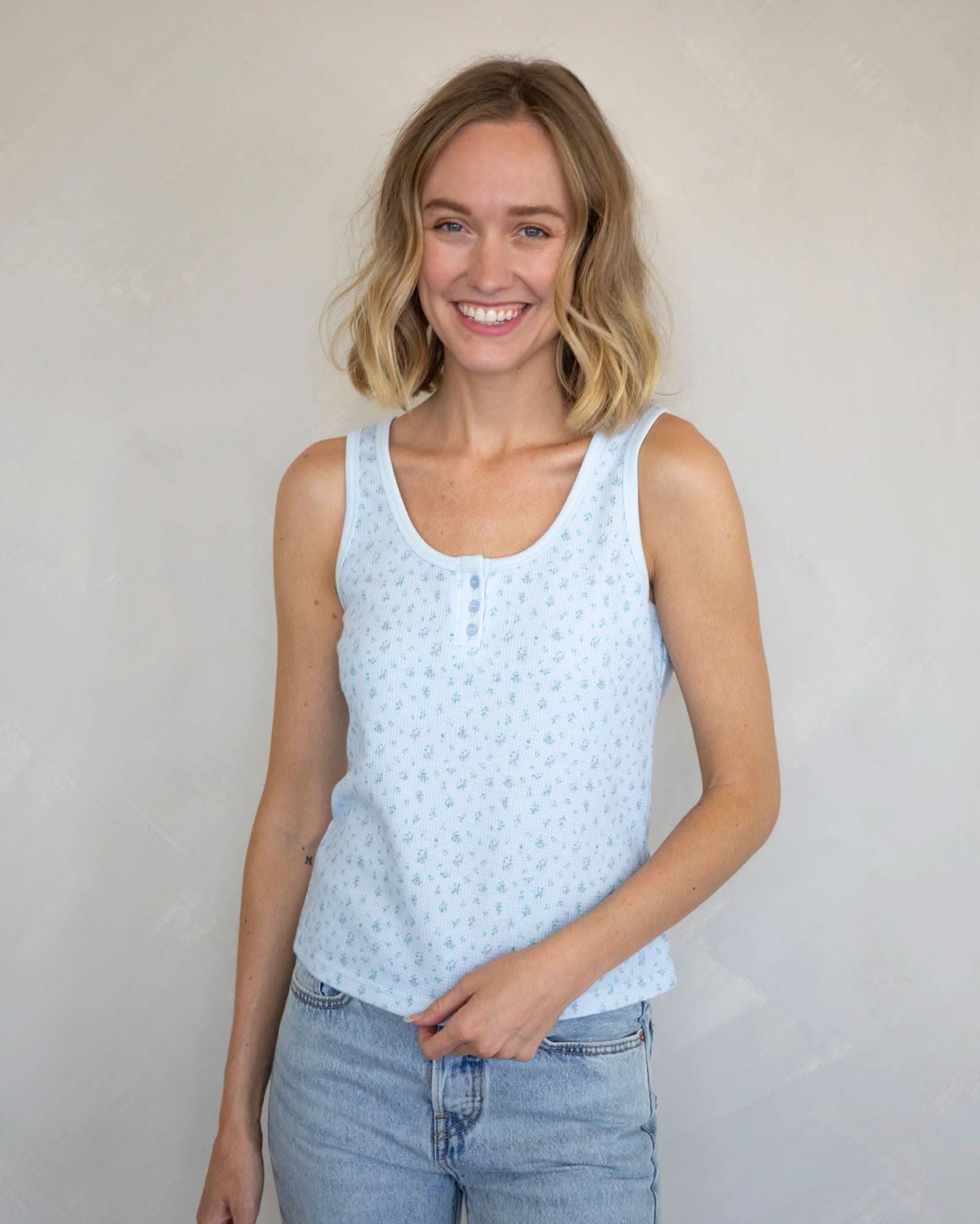 Woman wearing a Waffle-knit henley tank top with a floral design in baby blue