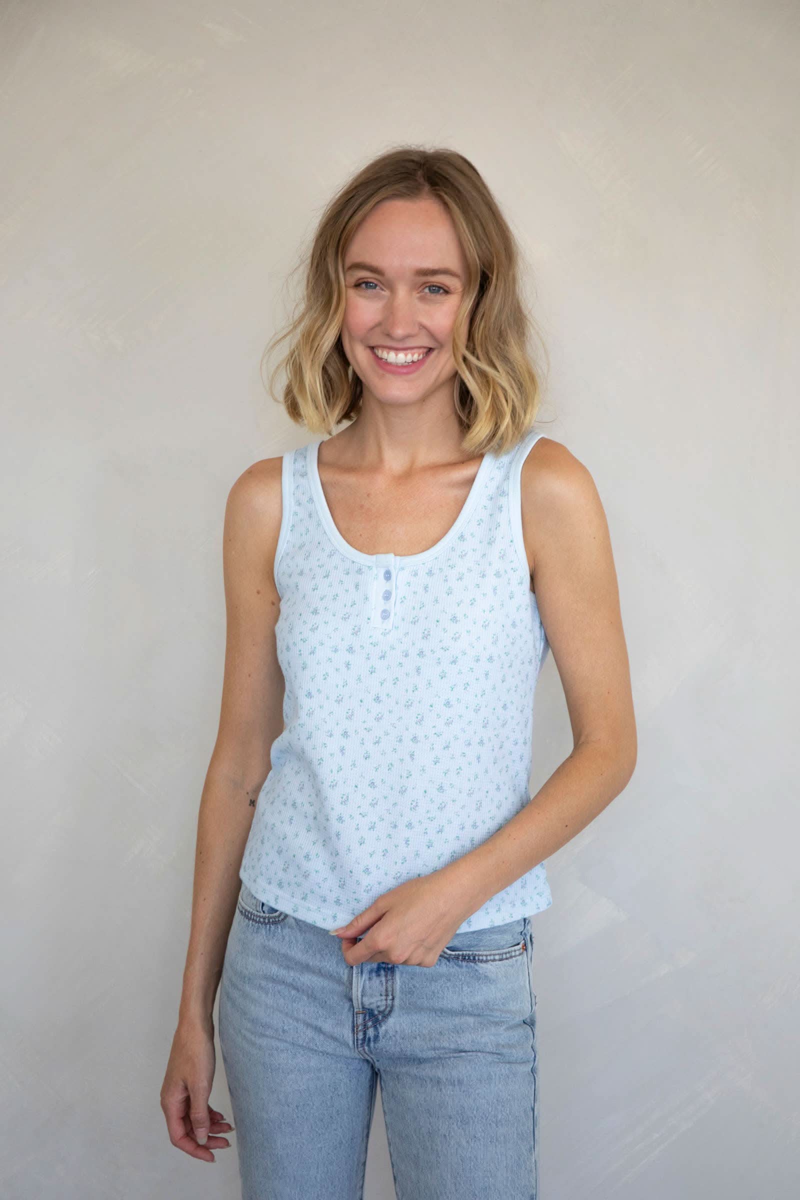 Woman wearing a Waffle-knit henley tank top with a floral design in baby blue
