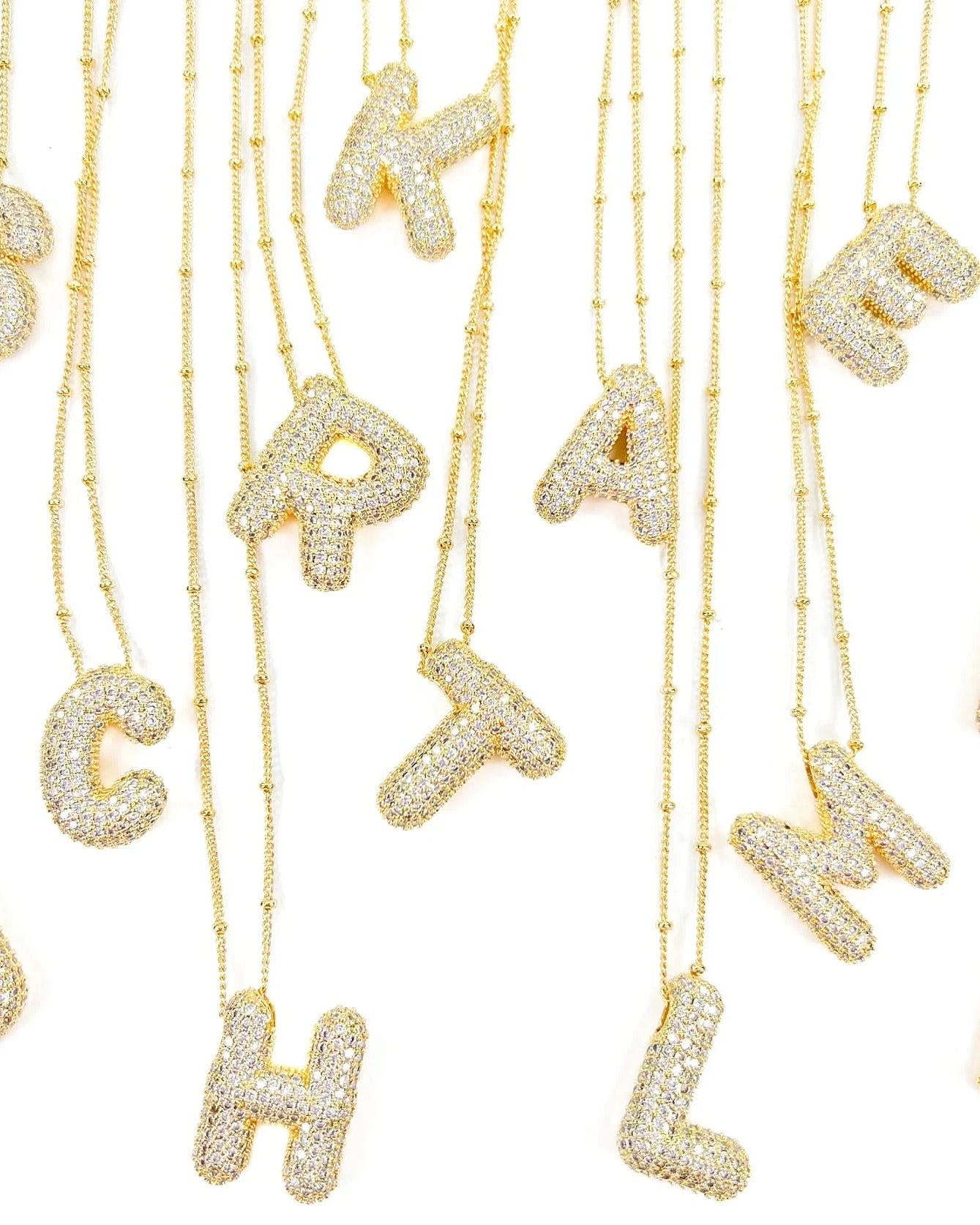A Bunch of gold necklaces with the Letters pendant - Form + Content