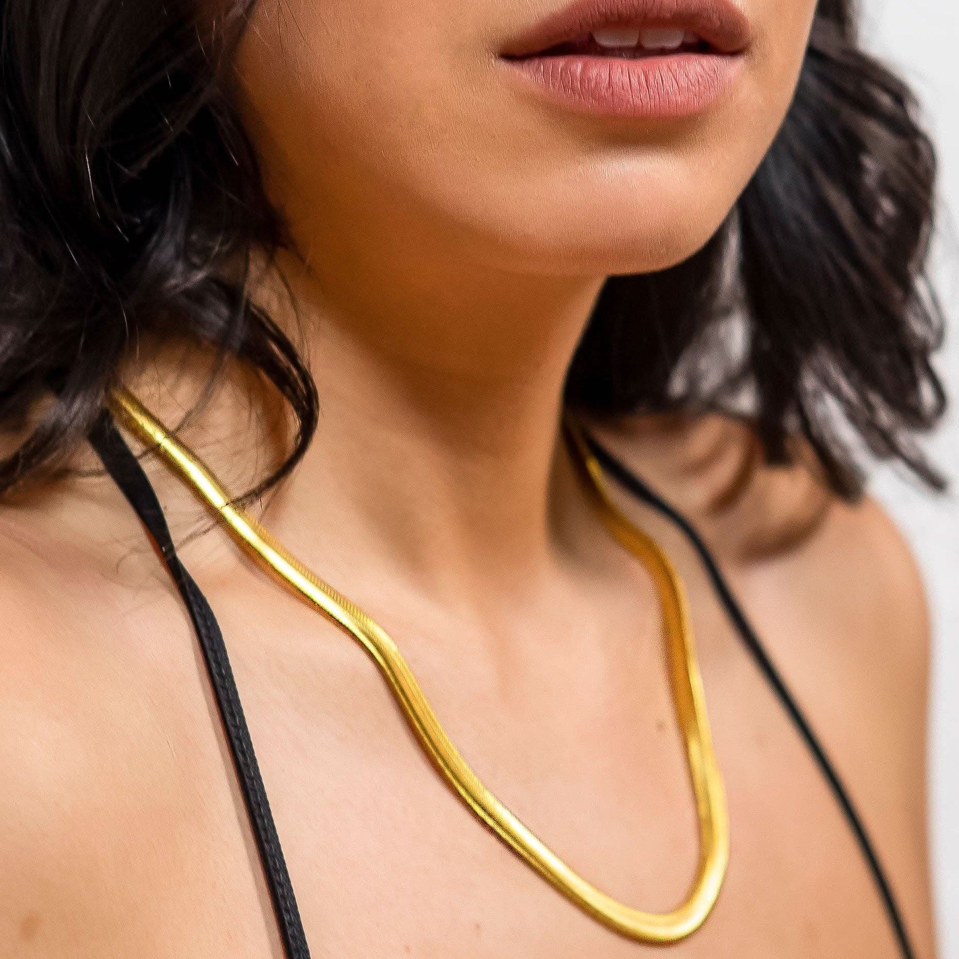 Woman wearing 18k gold 15inch to 17 inch herringbone necklace
