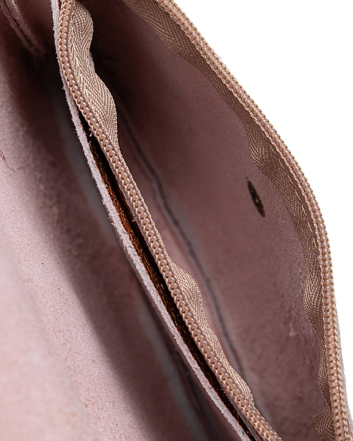 Close-up of the interior of a dusty rose or mauve zippered pouch or wallet, showing the fabric lining and zipper track against a white background.