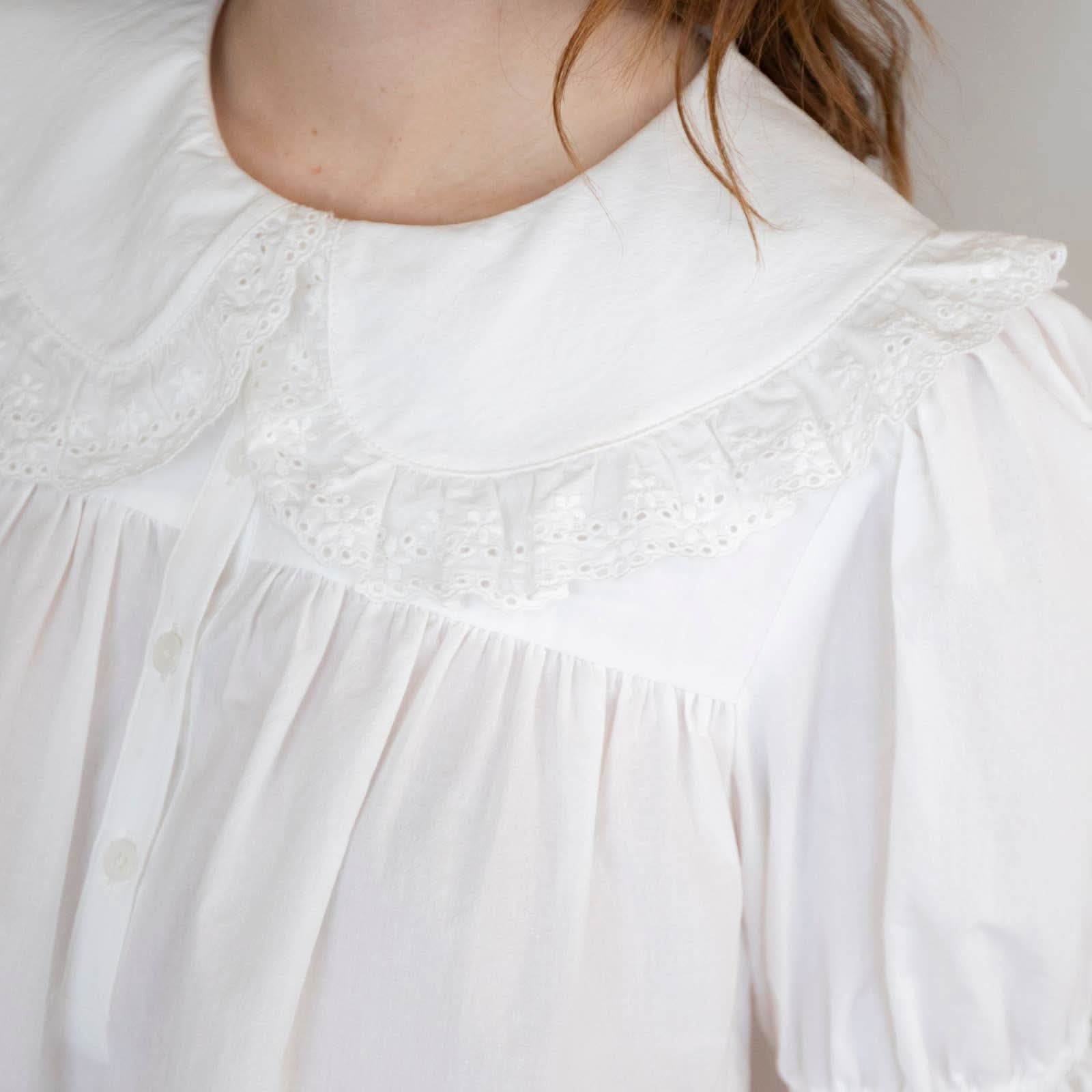 Close up on Woman wearing white collared and half button dreamy sweetheart blouse