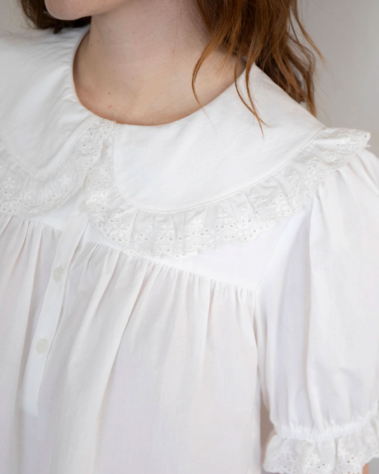 Close up on Woman wearing white collared and half button dreamy sweetheart blouse