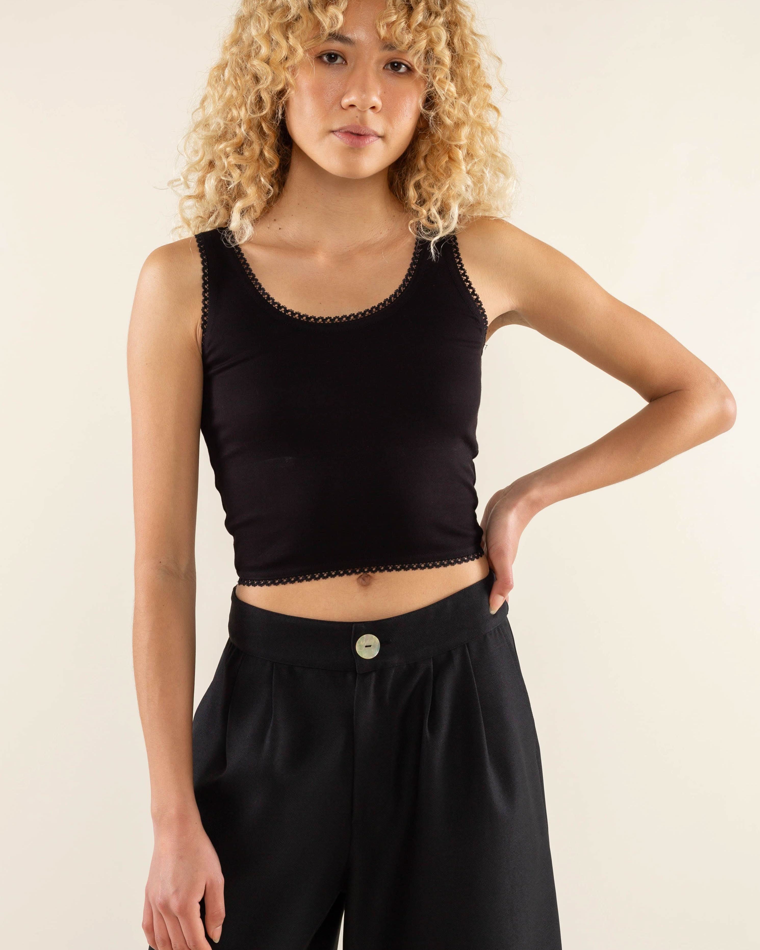 Woman wearing black, scallop trim, crop top with black jorts