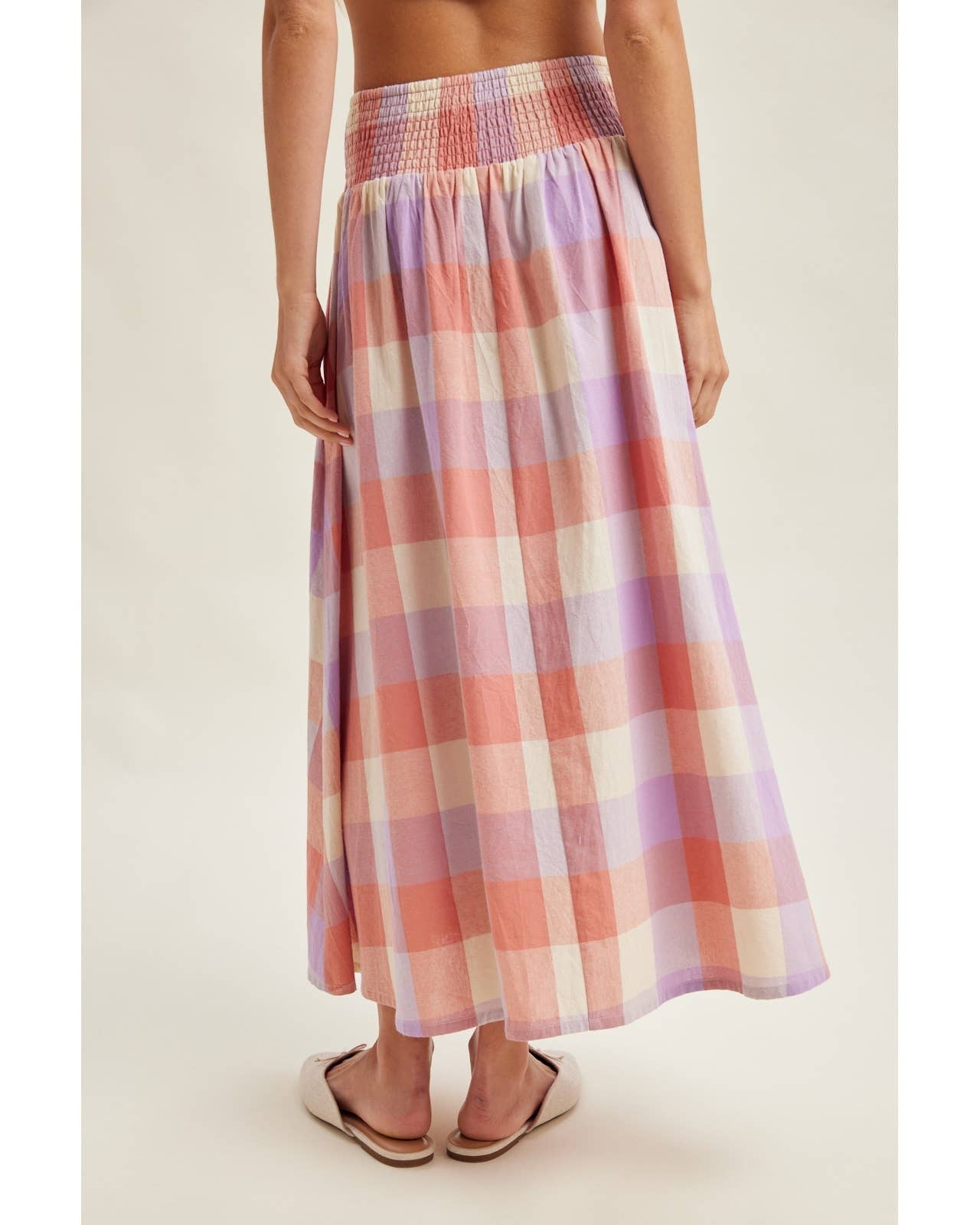 Person wearing a plaid skirt on a plain background