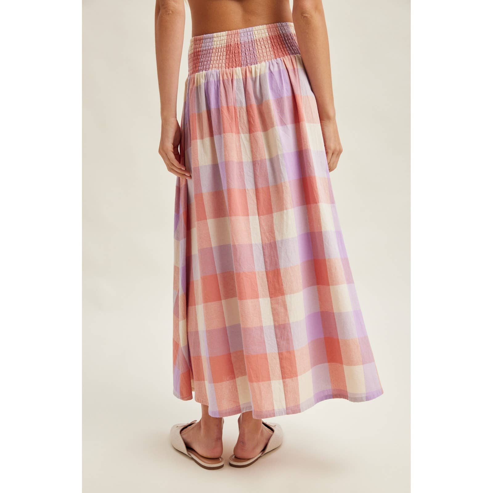 Person wearing a plaid skirt on a plain background