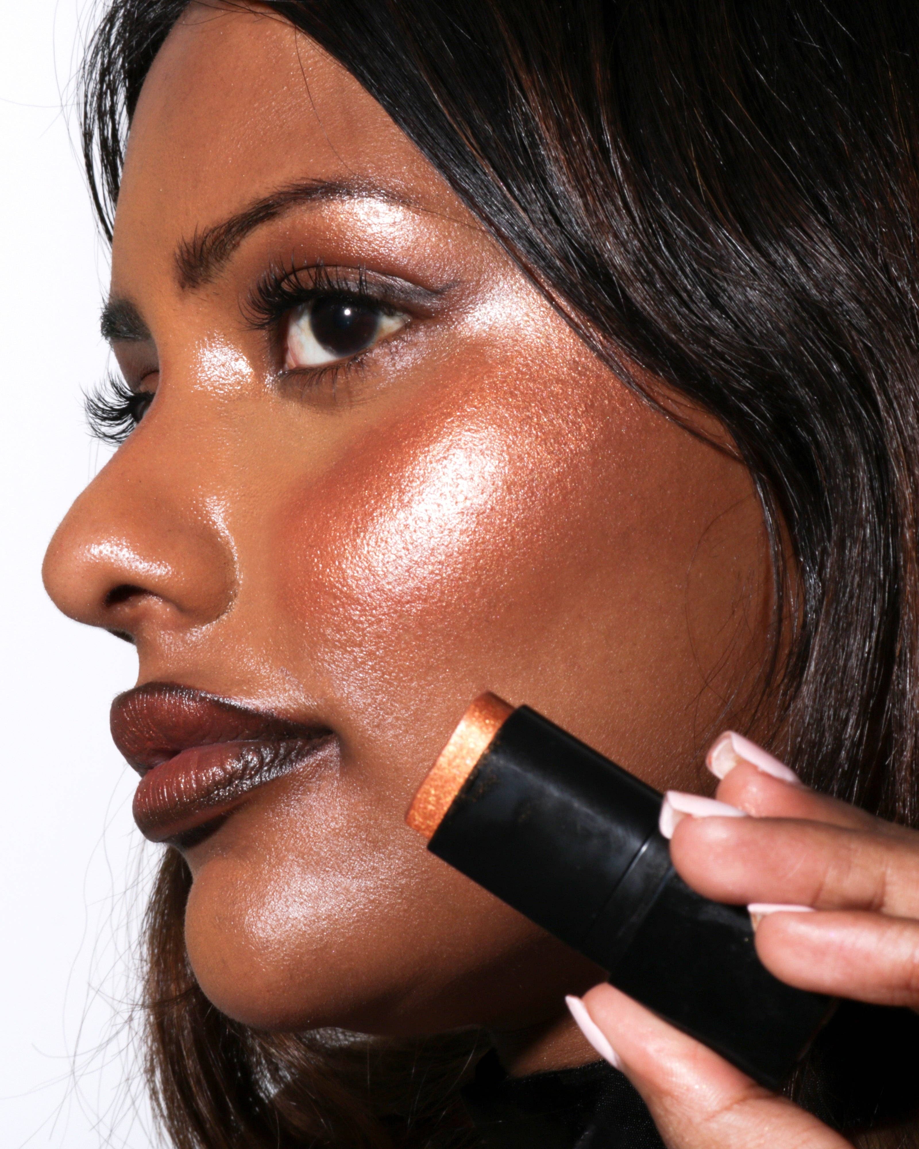 Woman applying bronzer to her face with a brush