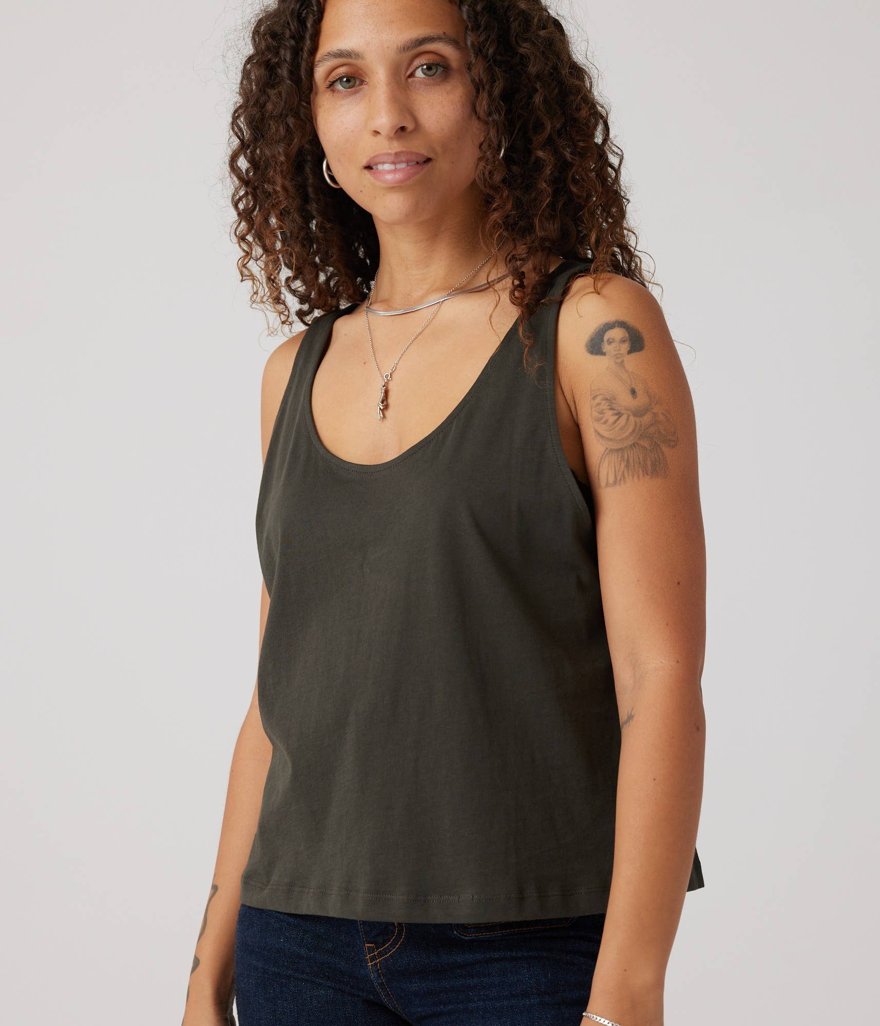 Woman wearing a dark green tank top against a plain background