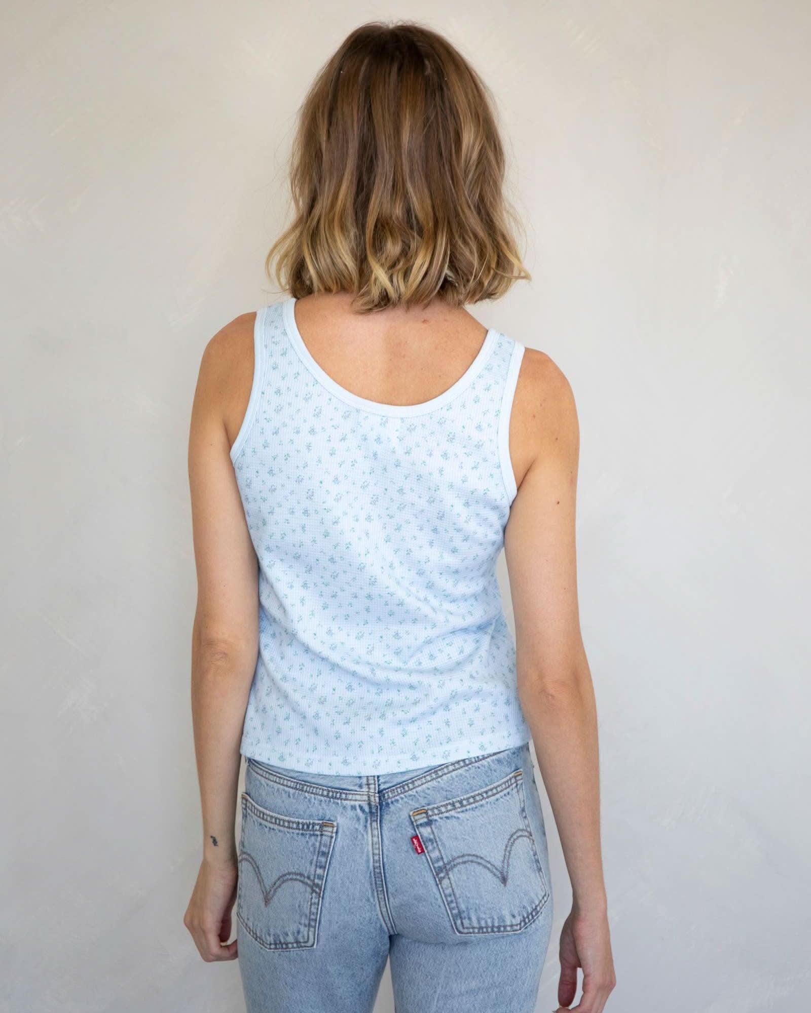 Woman wearing Waffle-knit henley tank top with a floral design in baby blue