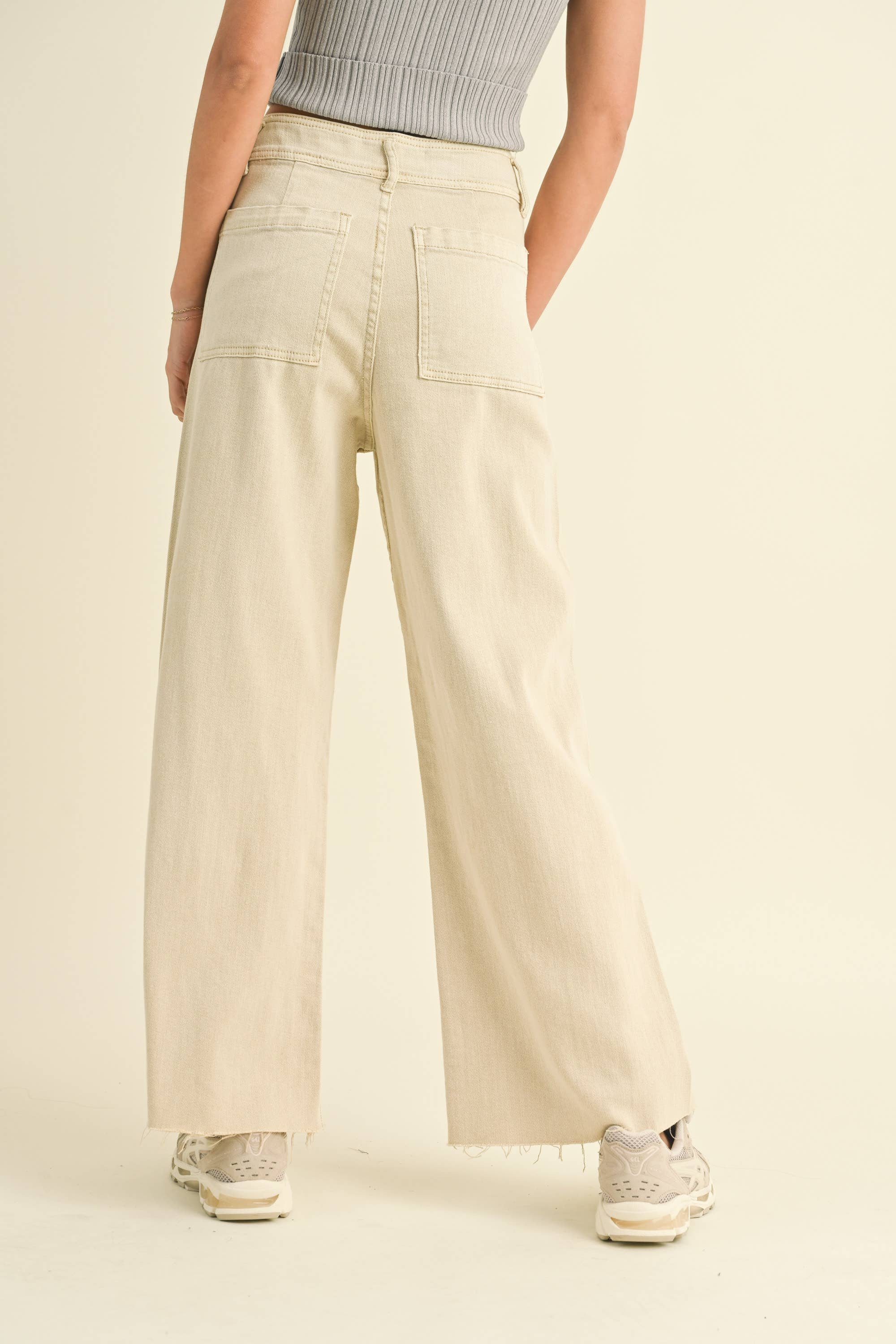 Beige wide-leg pants worn by a person on a beige background
