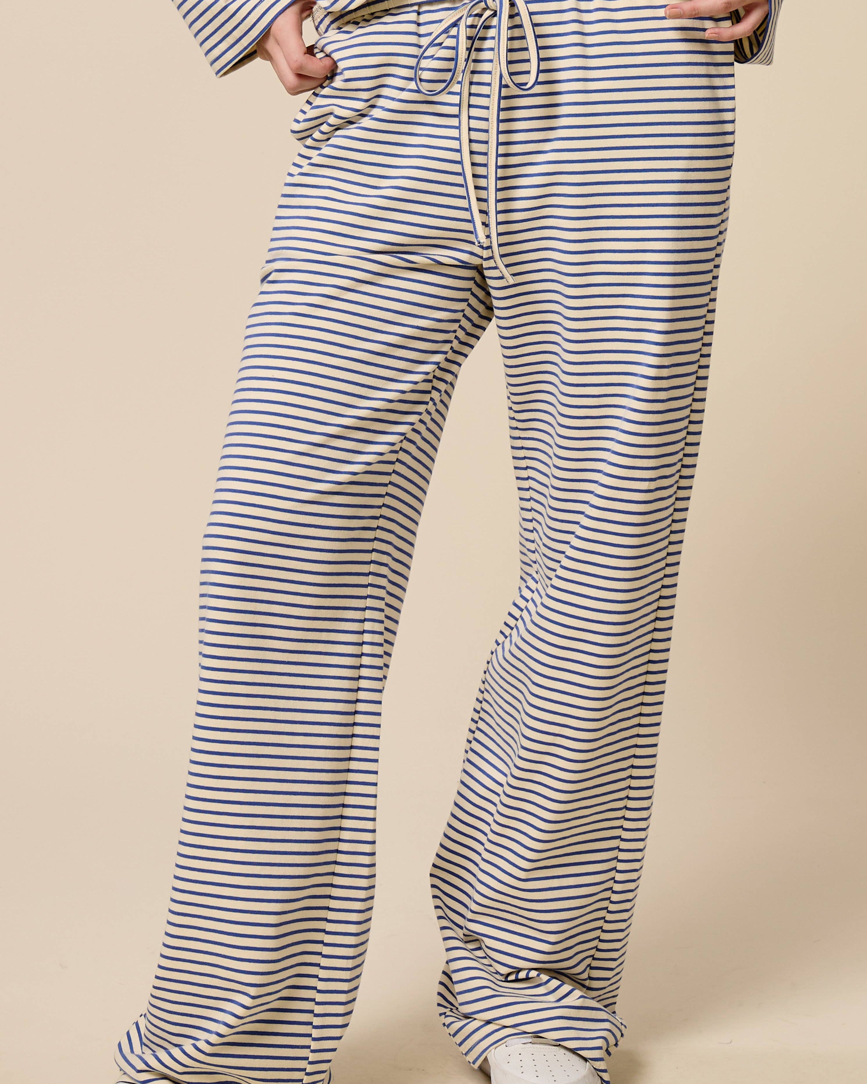 Person wearing blue and white striped pants on a beige background