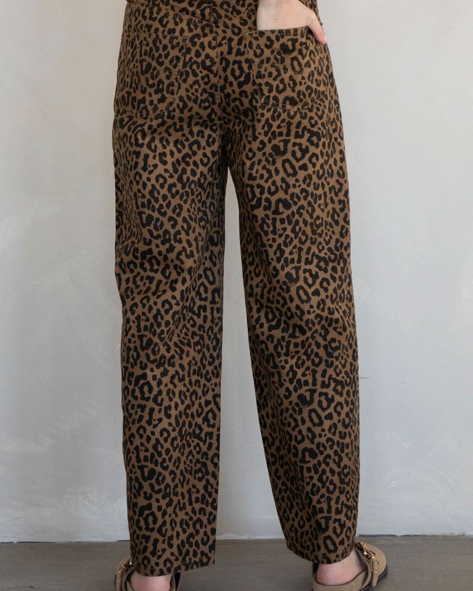Leopard print pants worn by a person against a plain background