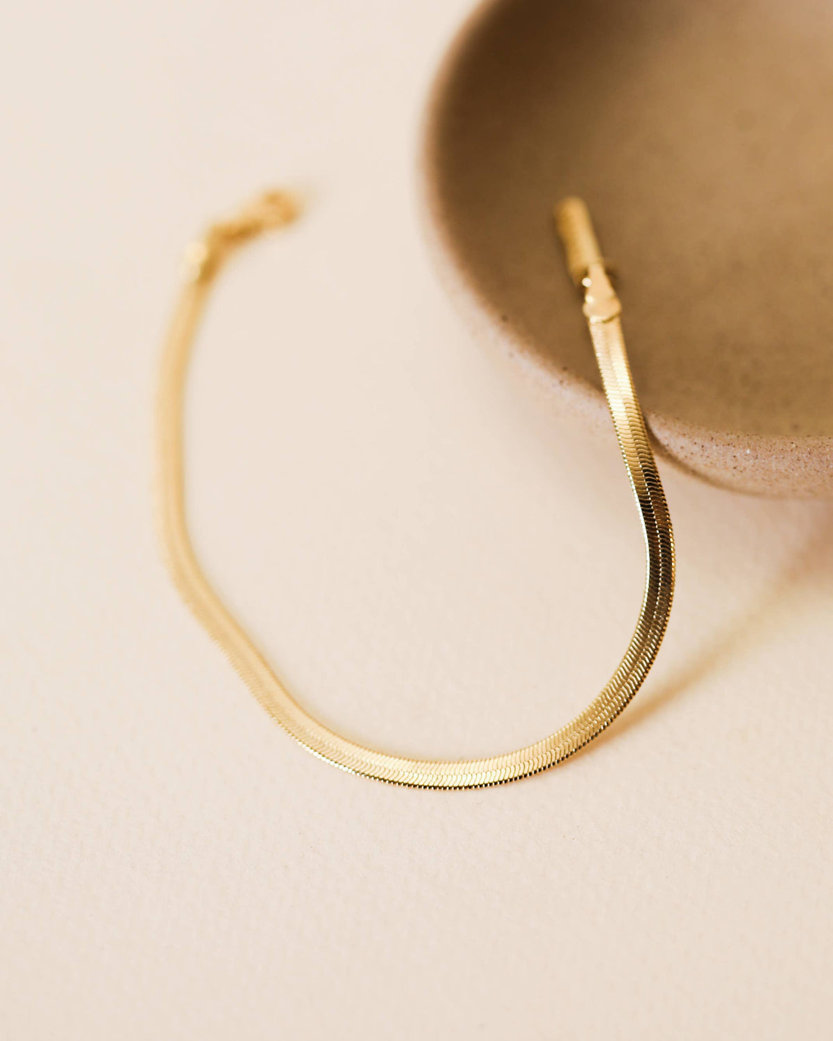 Gold bracelet on a beige background