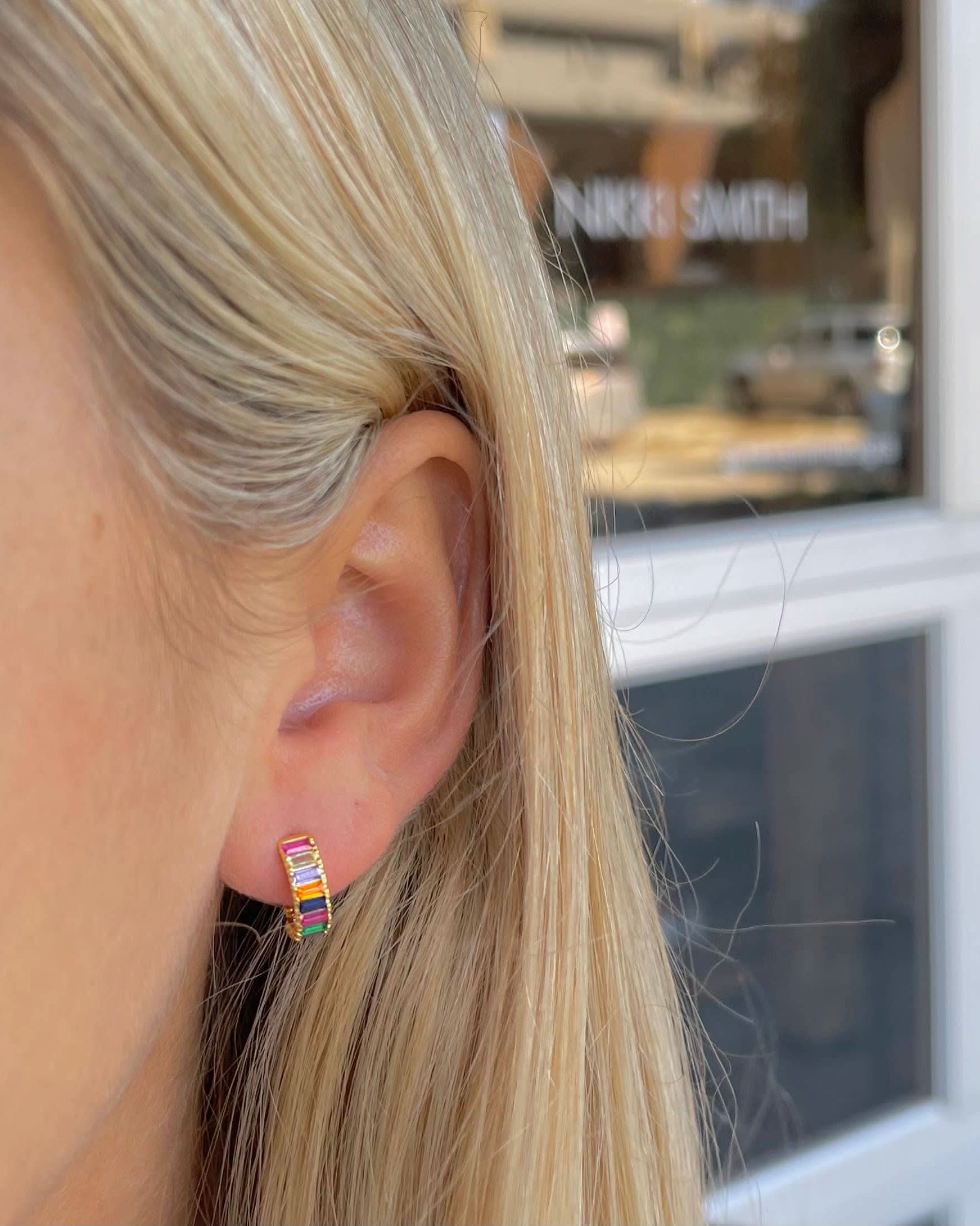 Woman wearing Small sized rainbow gem huggie earrings