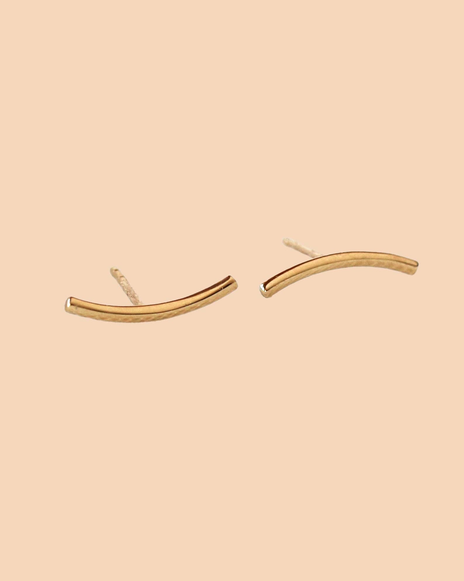 Gold earrings on a beige background