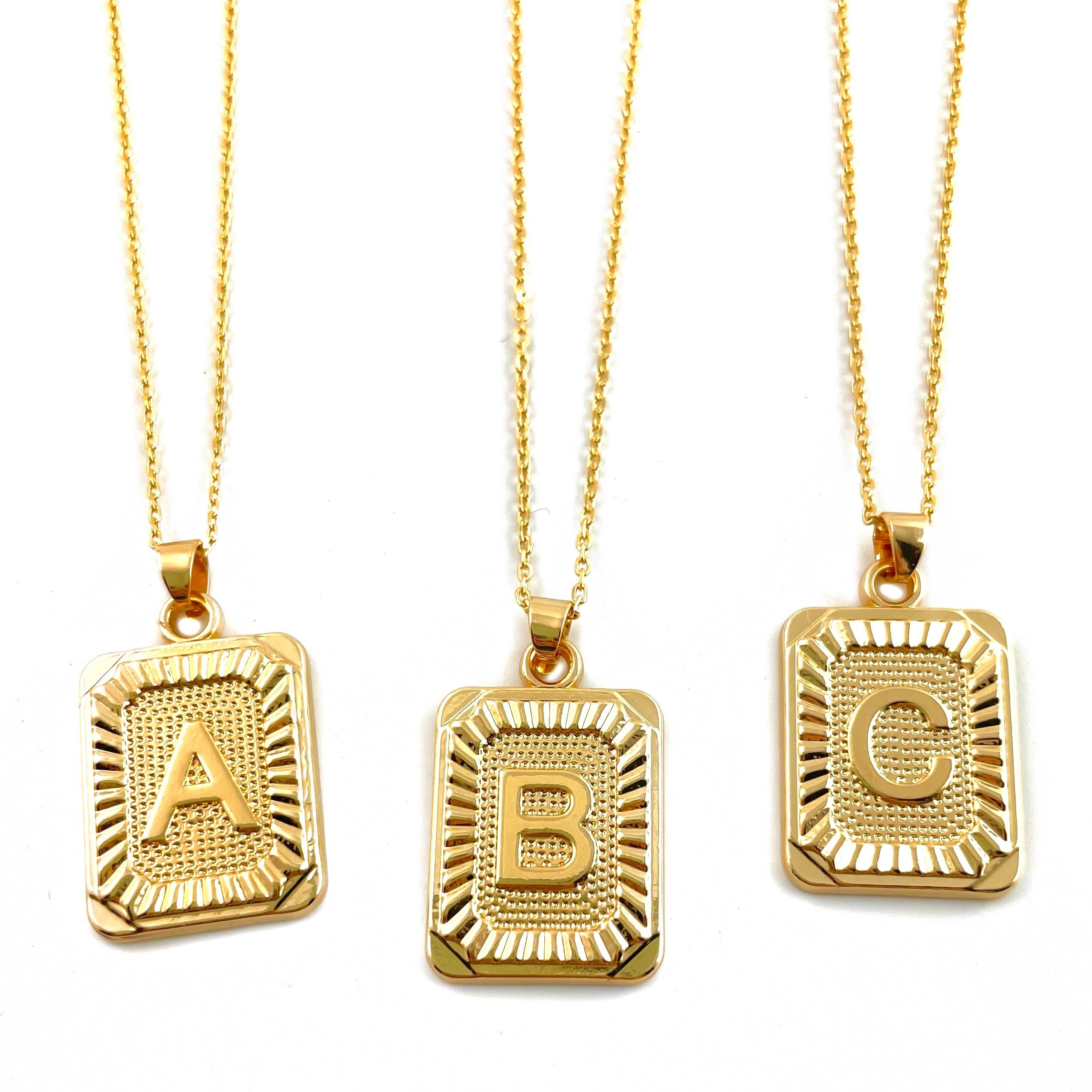 Letter A, B, and C tarnish free gold initial charm necklaces behind a blank background.