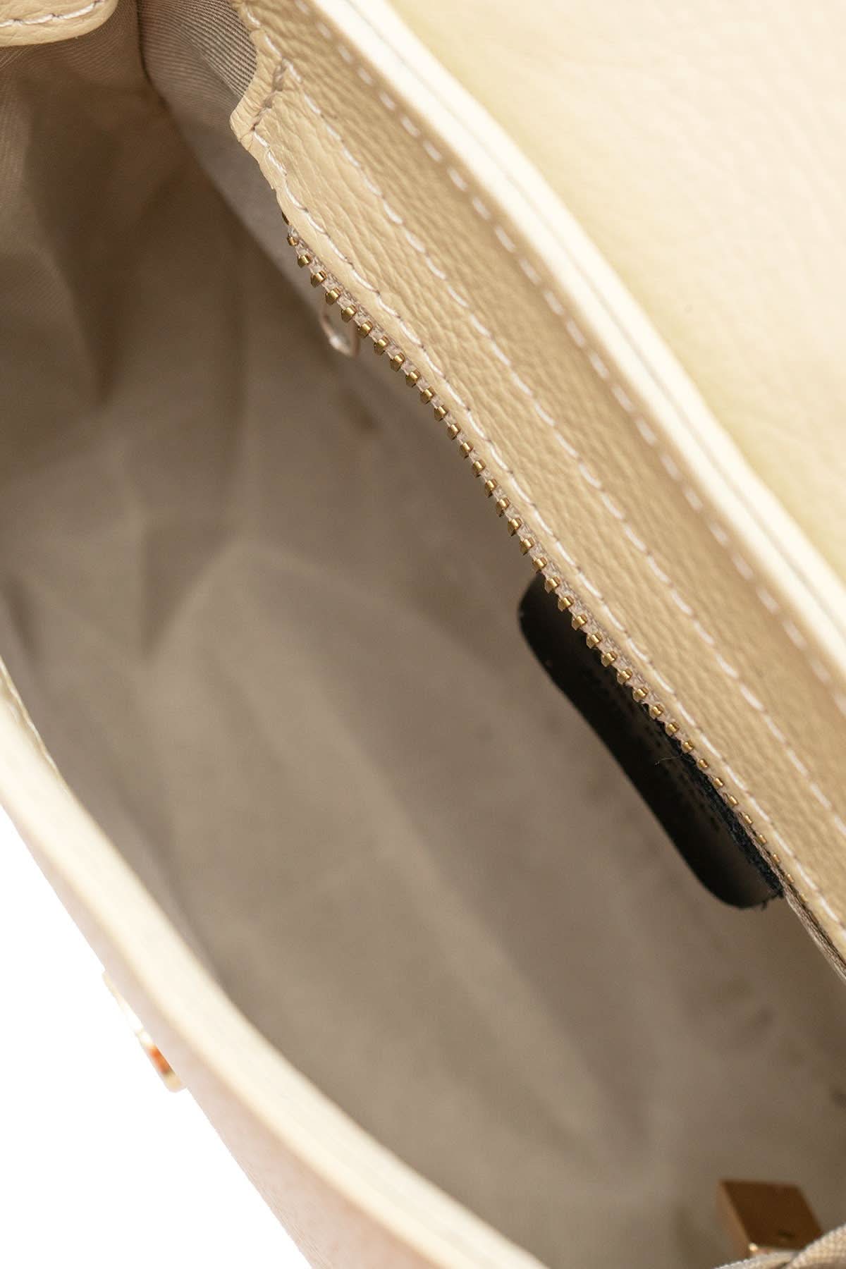 Inside view of Cream colored leather crossbody bag with magnetic front clap and leather woven geometric design and gold Metal details