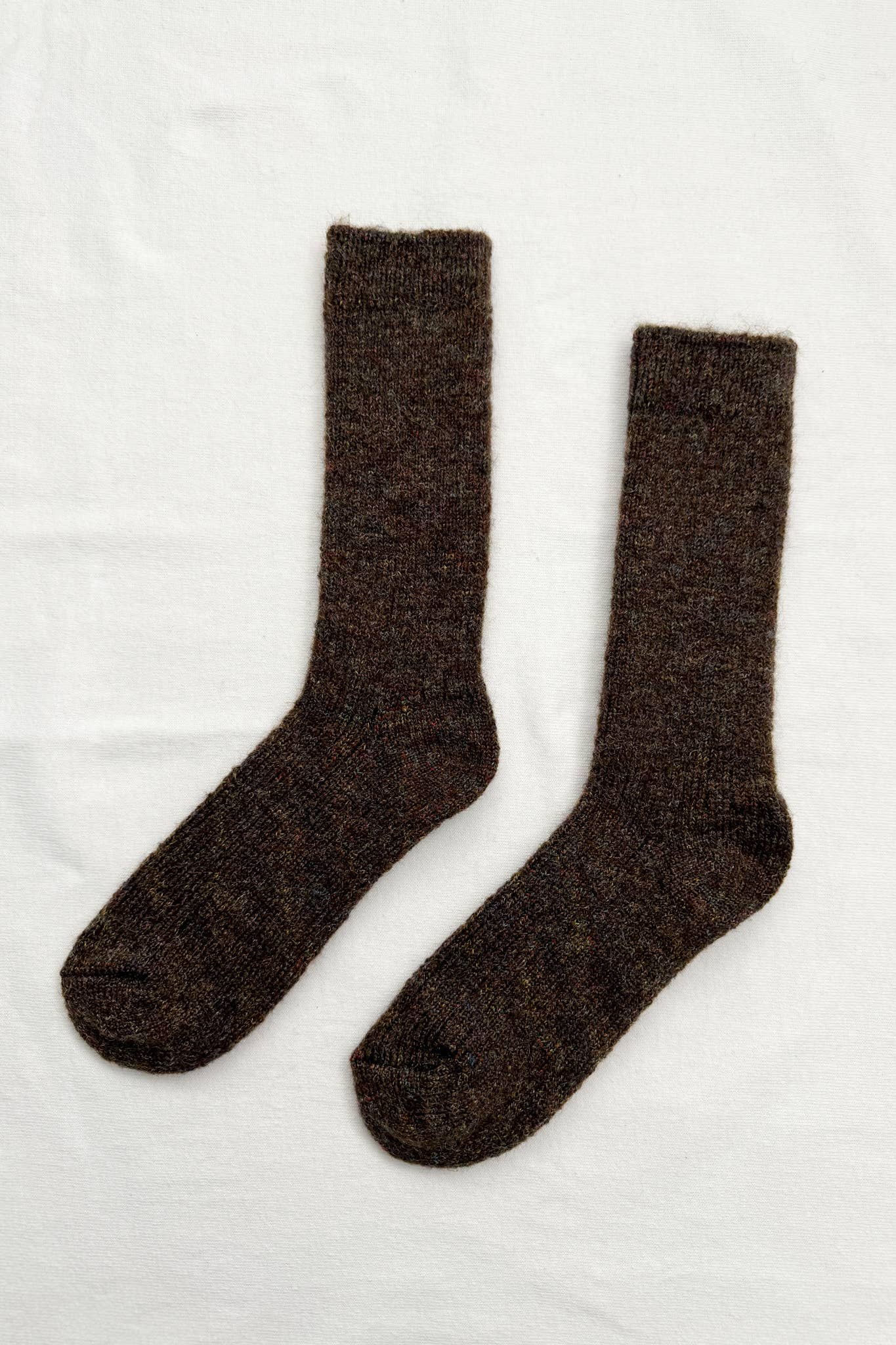 Pair of dark brown fuzzy socks on a white background