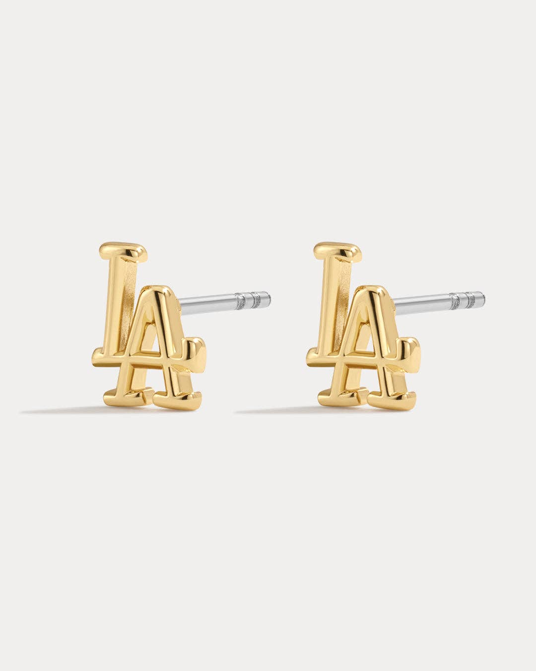 Gold earrings with 'LA' design on a white background