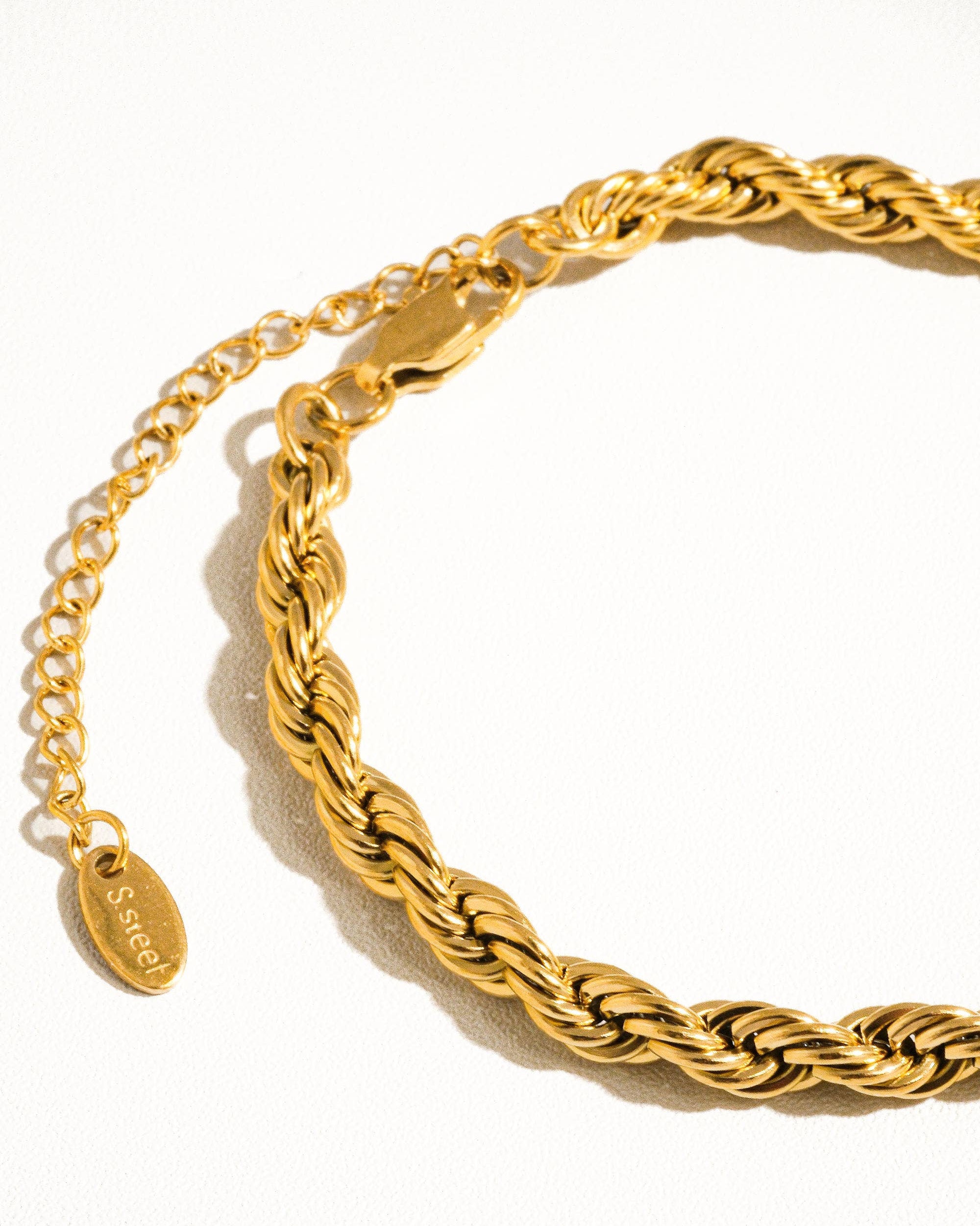 Gold braided bracelet on a white background