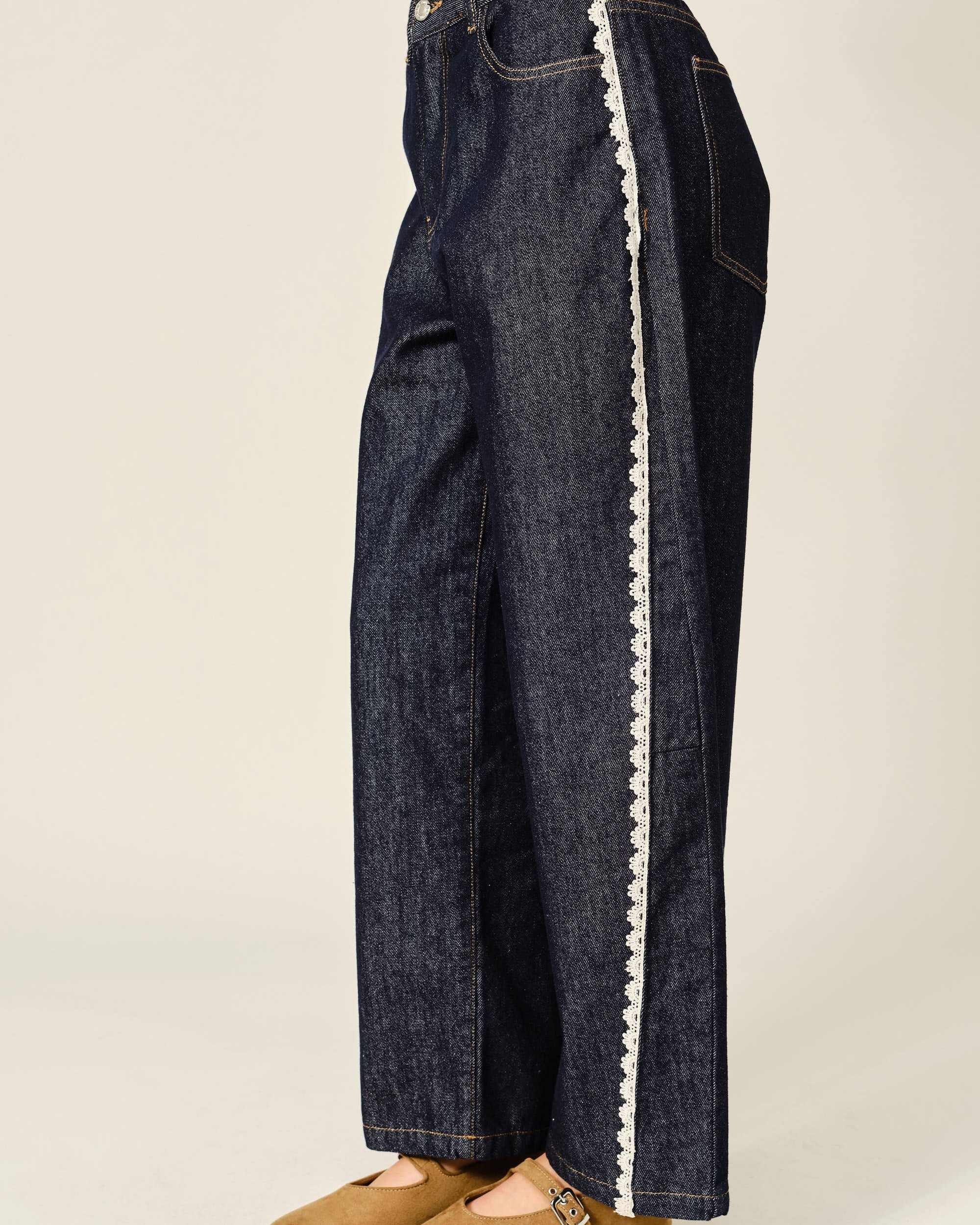 Dark blue jeans with white trim on a plain background