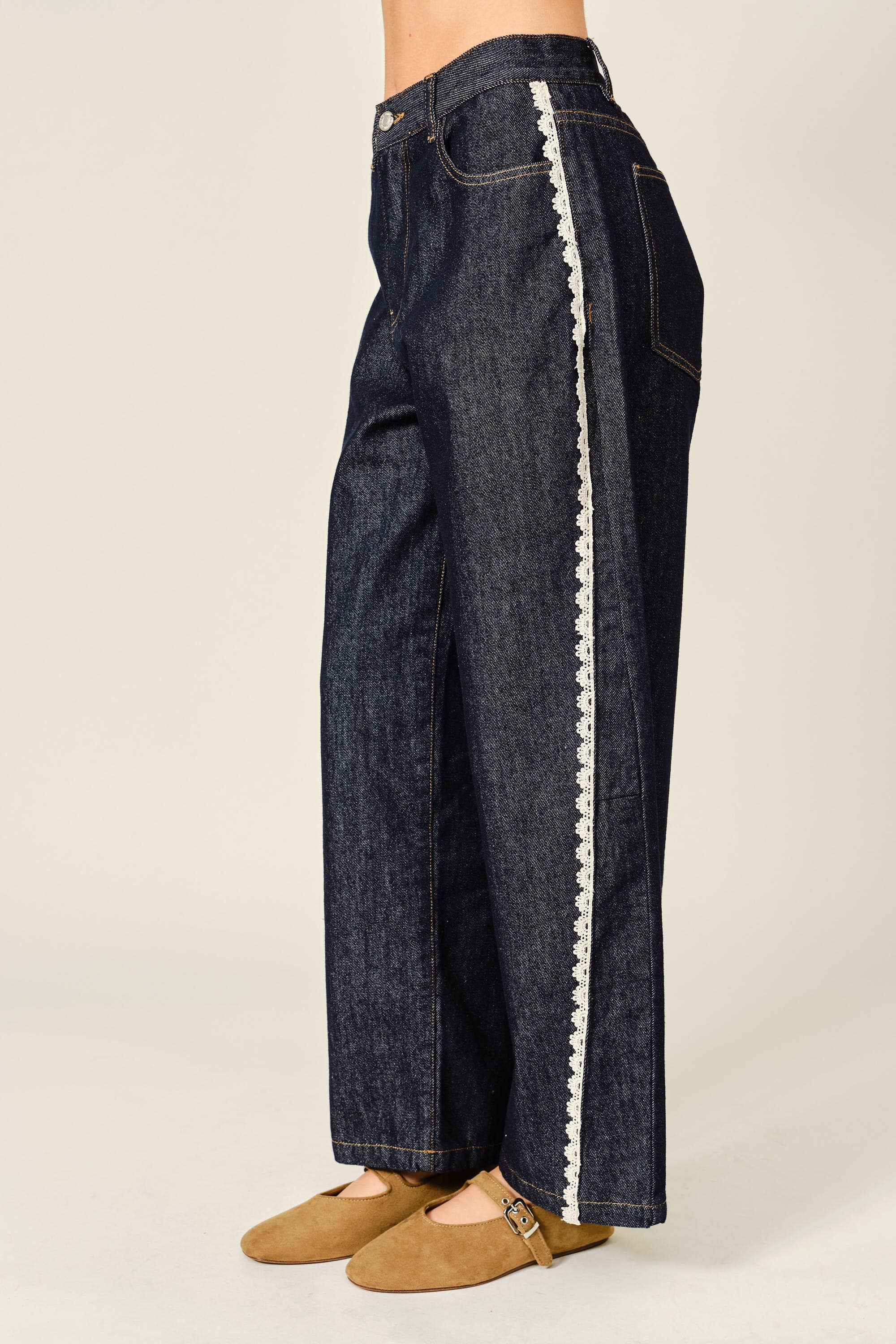 Dark blue jeans with white trim on a plain background