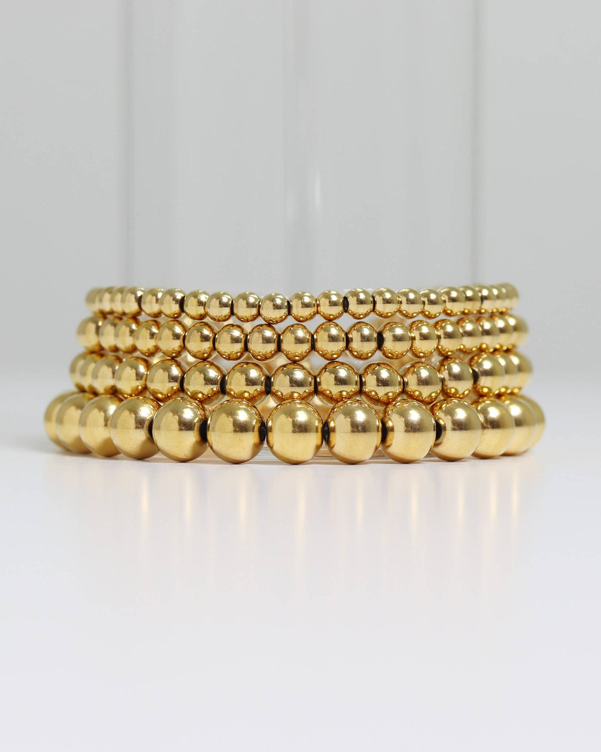 Gold beaded bracelet on a black background