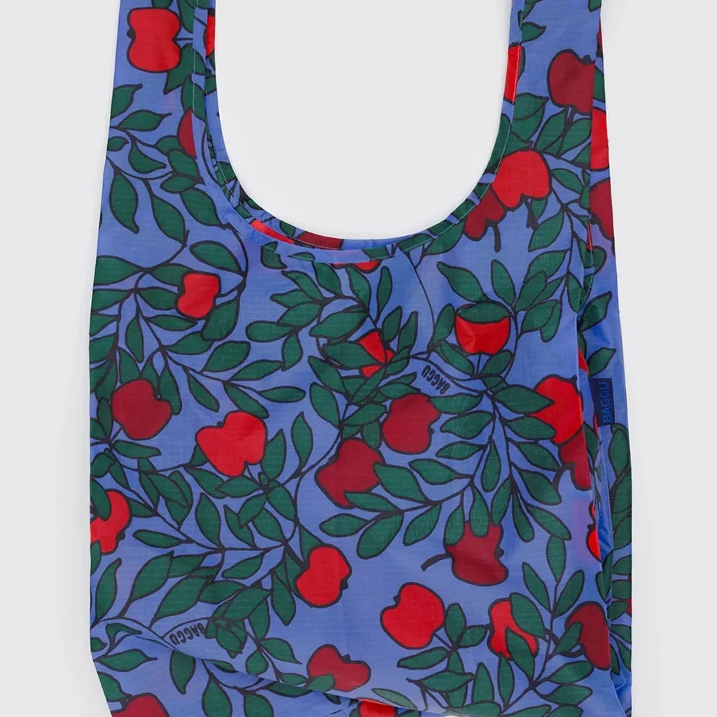 Reusable bag with red apple and green leaves pattern on a purple background
