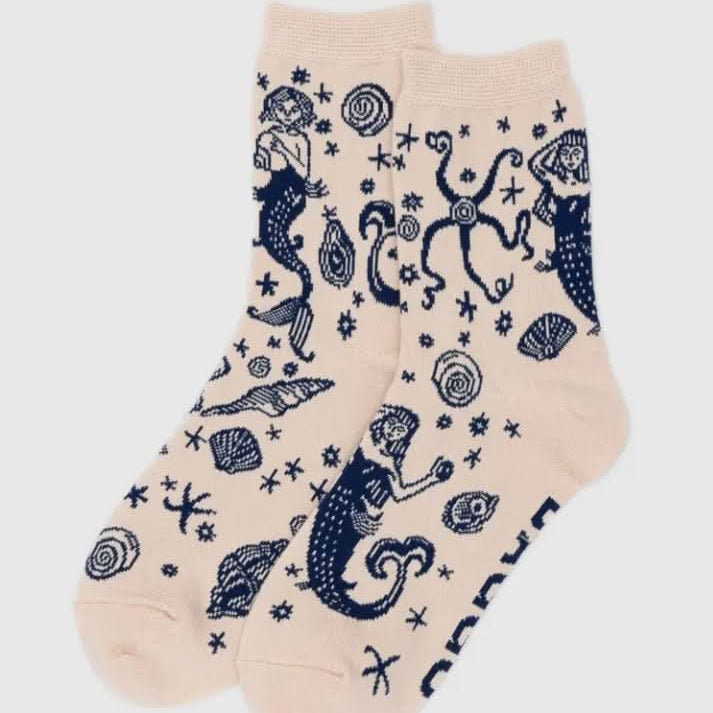 Beige socks with navy mermaid and shell pattern on a white background