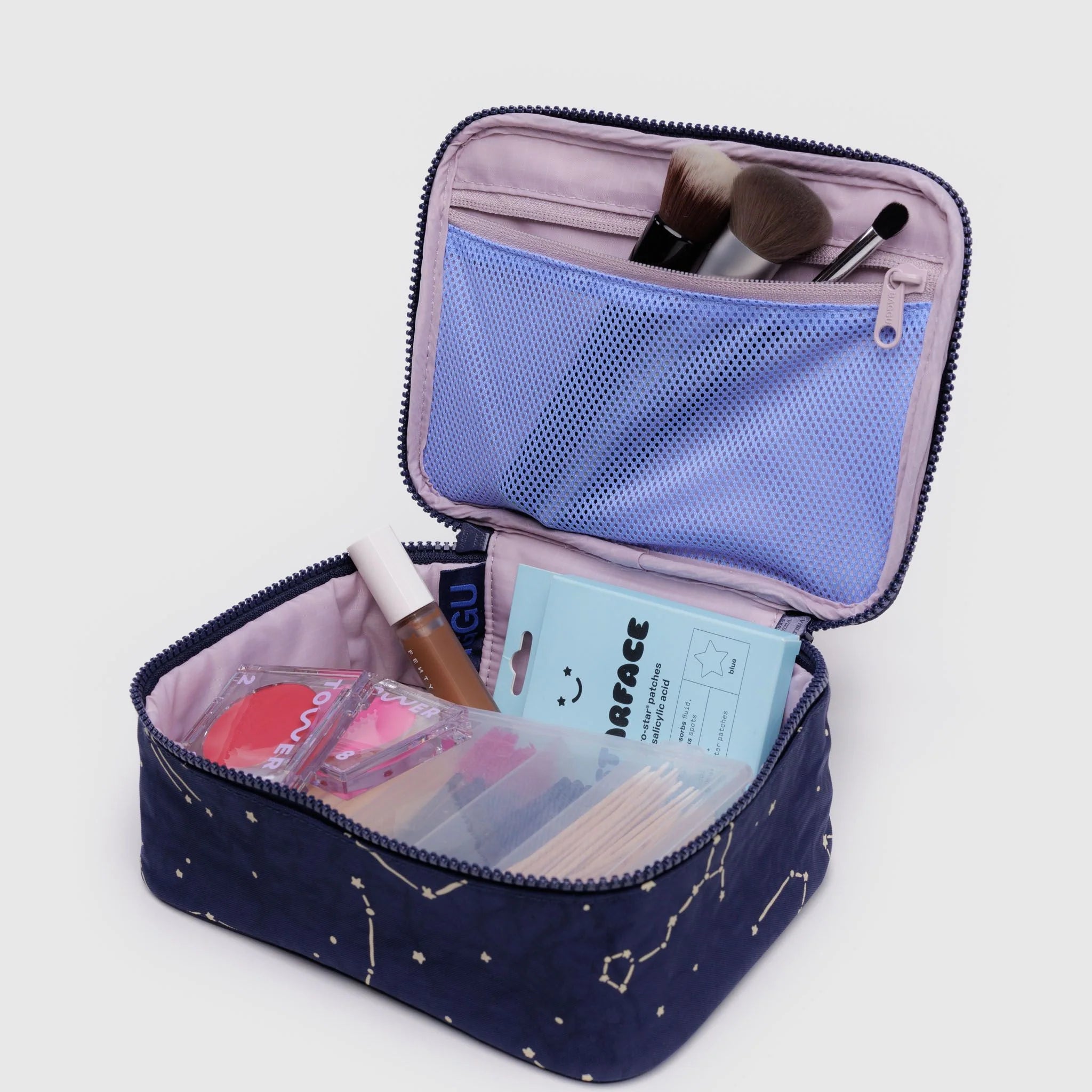 Open makeup bag with cosmetic items on a light gray background