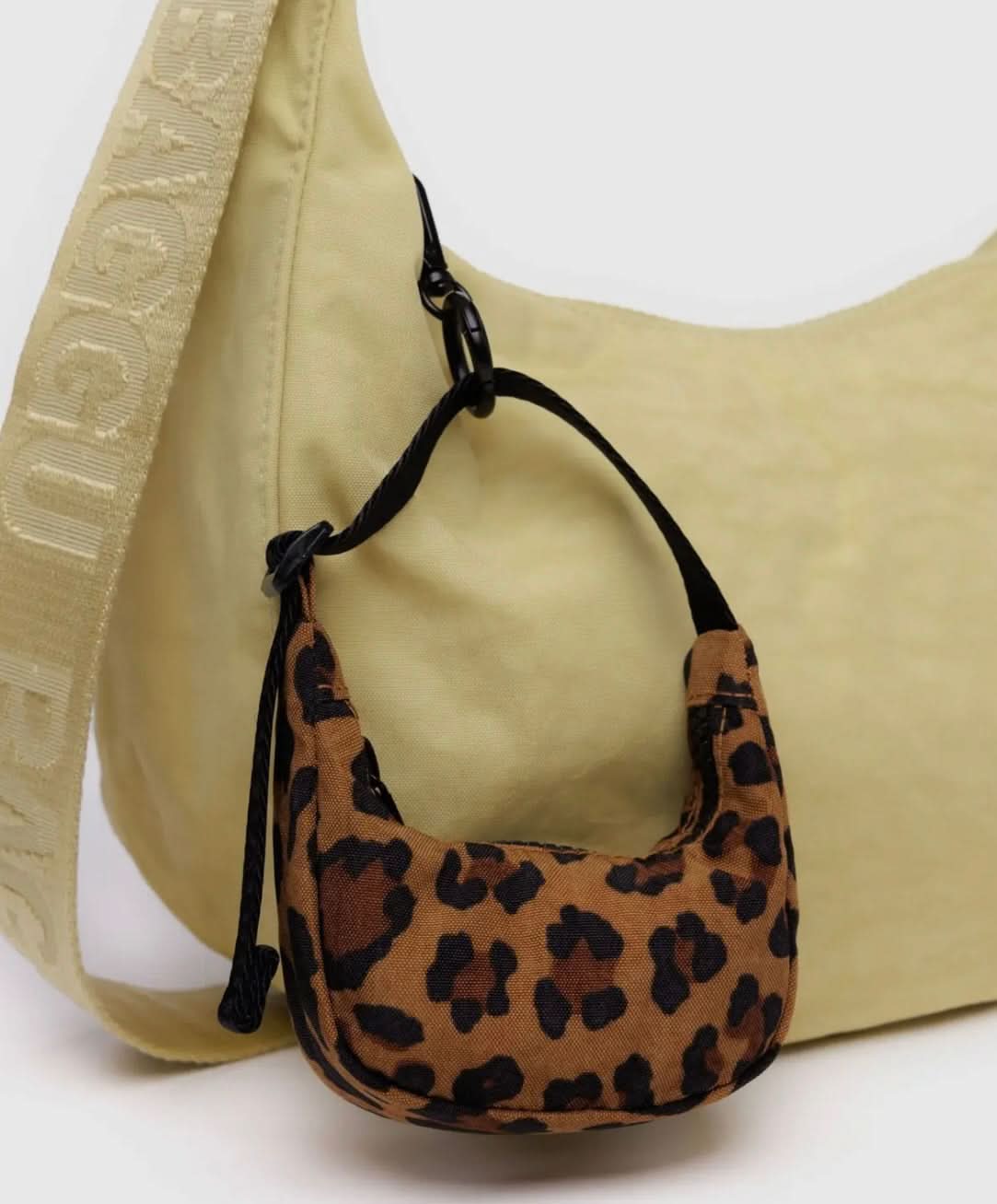 Tiny leopard baby BAGGU bag charm, Fully functional zipper, clipped to a bigger yellow BAGGU bag