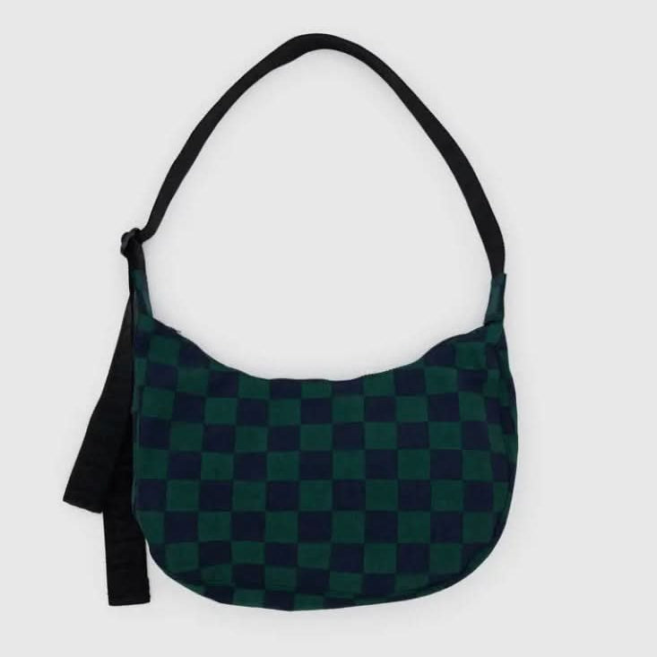 Green and black checkered bag with a black strap on a light gray background