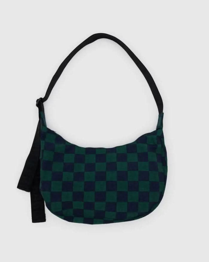 Green and black checkered bag with a black strap on a light gray background