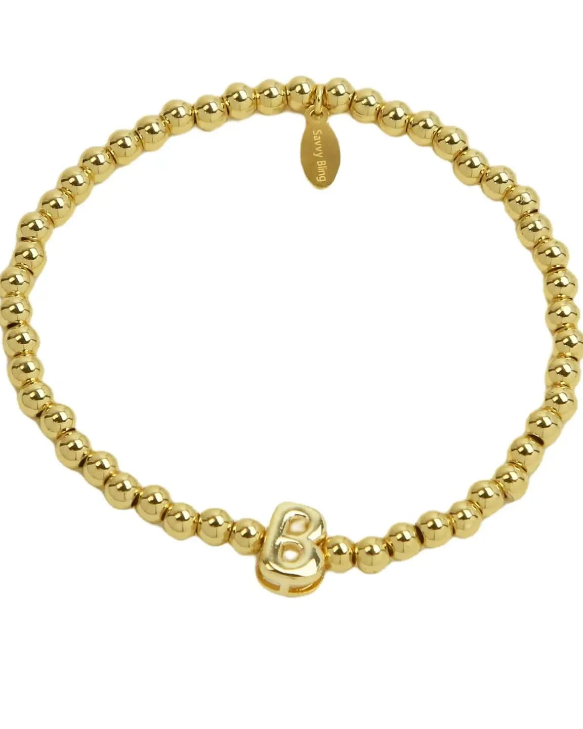 Gold beaded bracelet with a heart charm on a white background